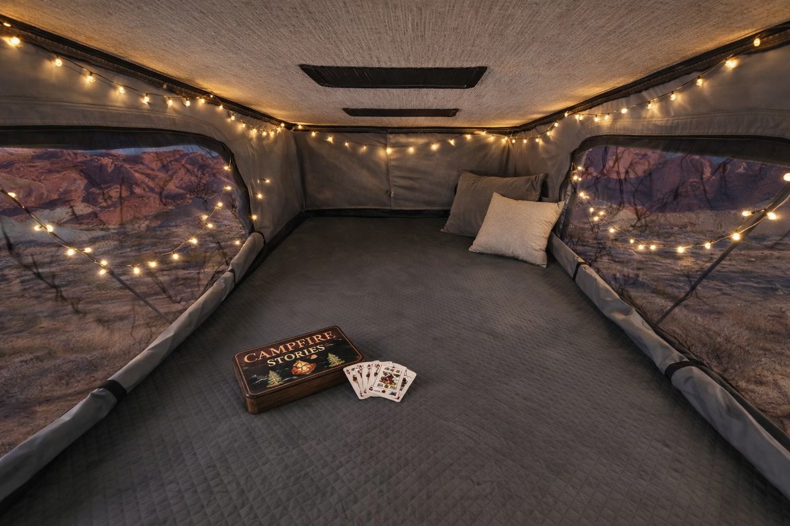 Cozy RV rental interior for glamping. String lights illuminate a comfy bed, scenic views, and Campfire Stories with playing cards.. Winnebago Solis 2025