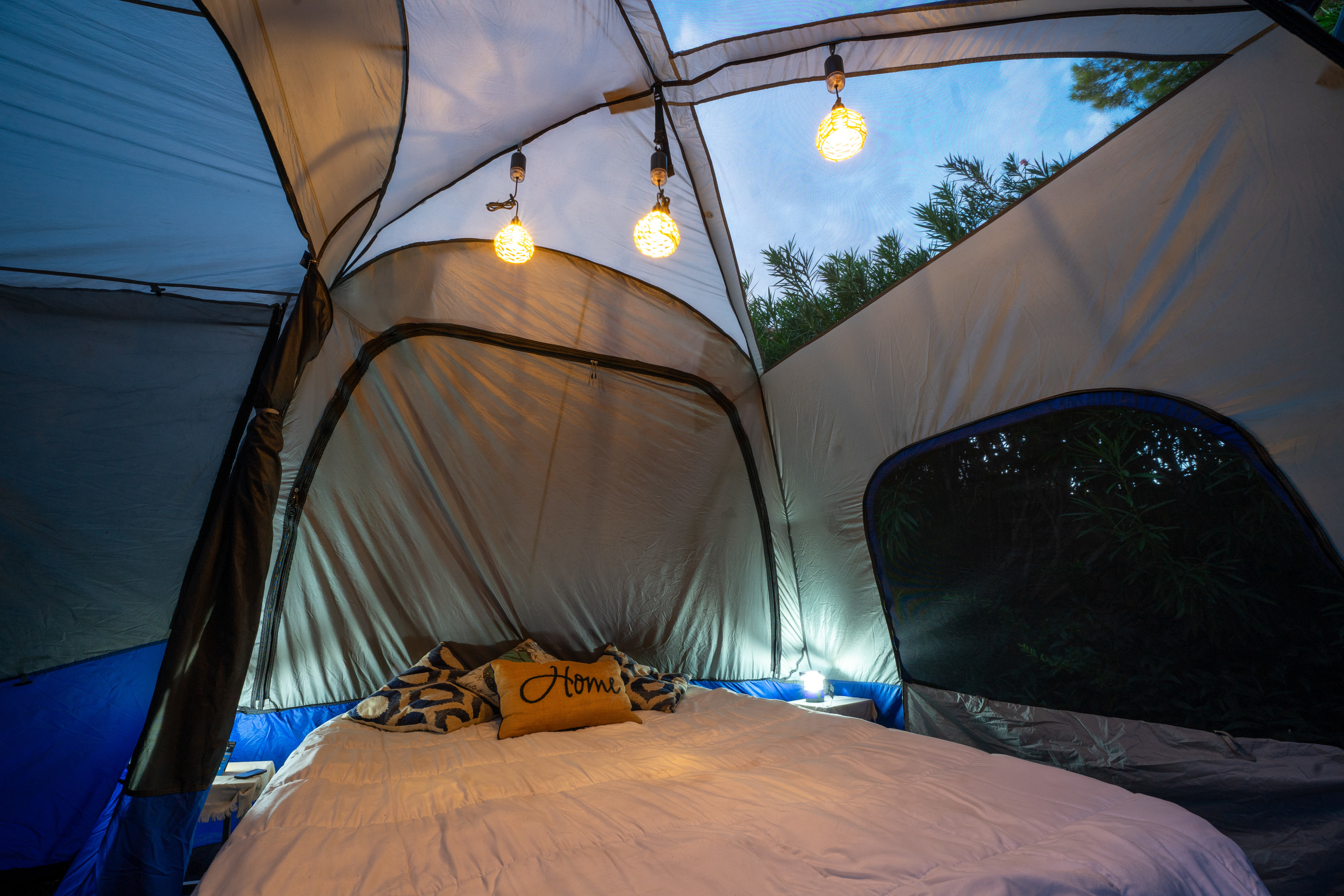 Cozy glamping tent interior with bed, ambient lights, and nature views, enhancing your RV rental camping adventure.. Fiat Jeep Wrangler Unlimited Willys 2021