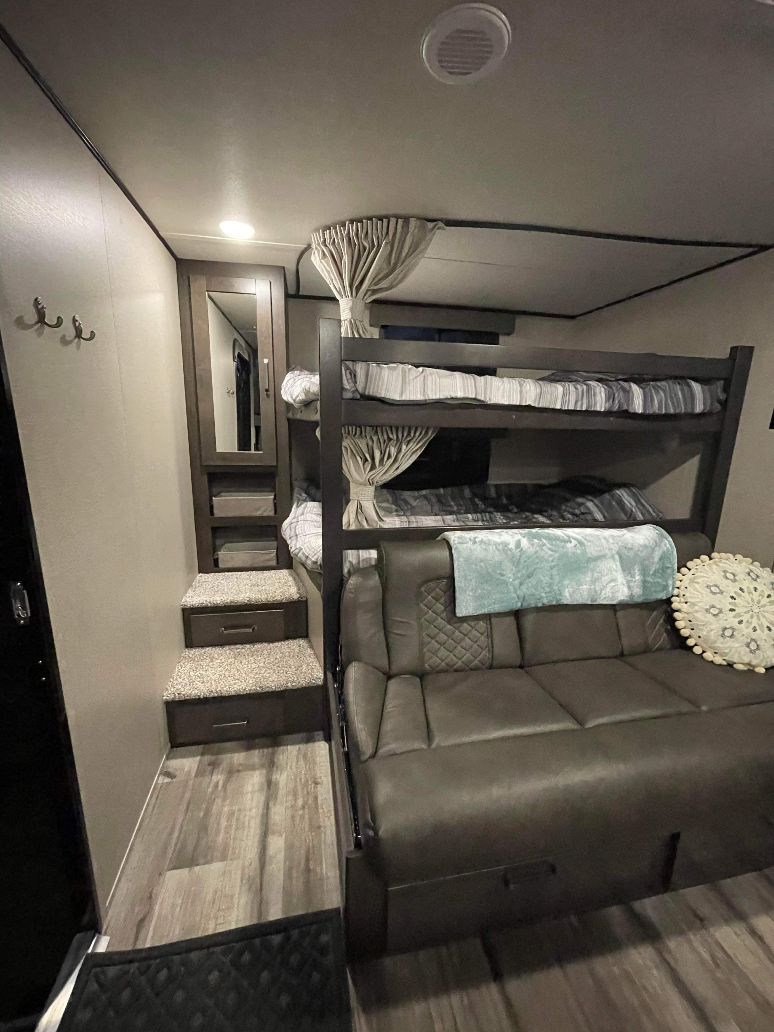 RV rental bunk room: features cozy bunk beds with curtains, a plush sofa, and multi-functional steps with storage.. Grand Design Transcend Xplor 2023