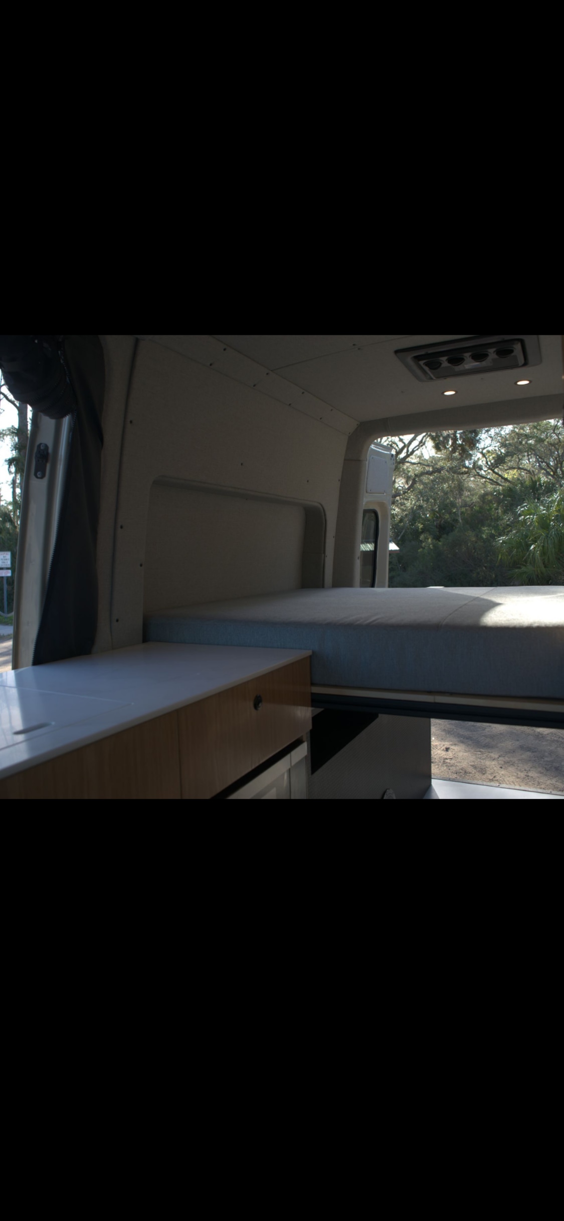 Inside this rv rental: comfy bed, sleek counter, and bright nature view. Ideal for road trips and camping.. Mercedes Motorhome 2025