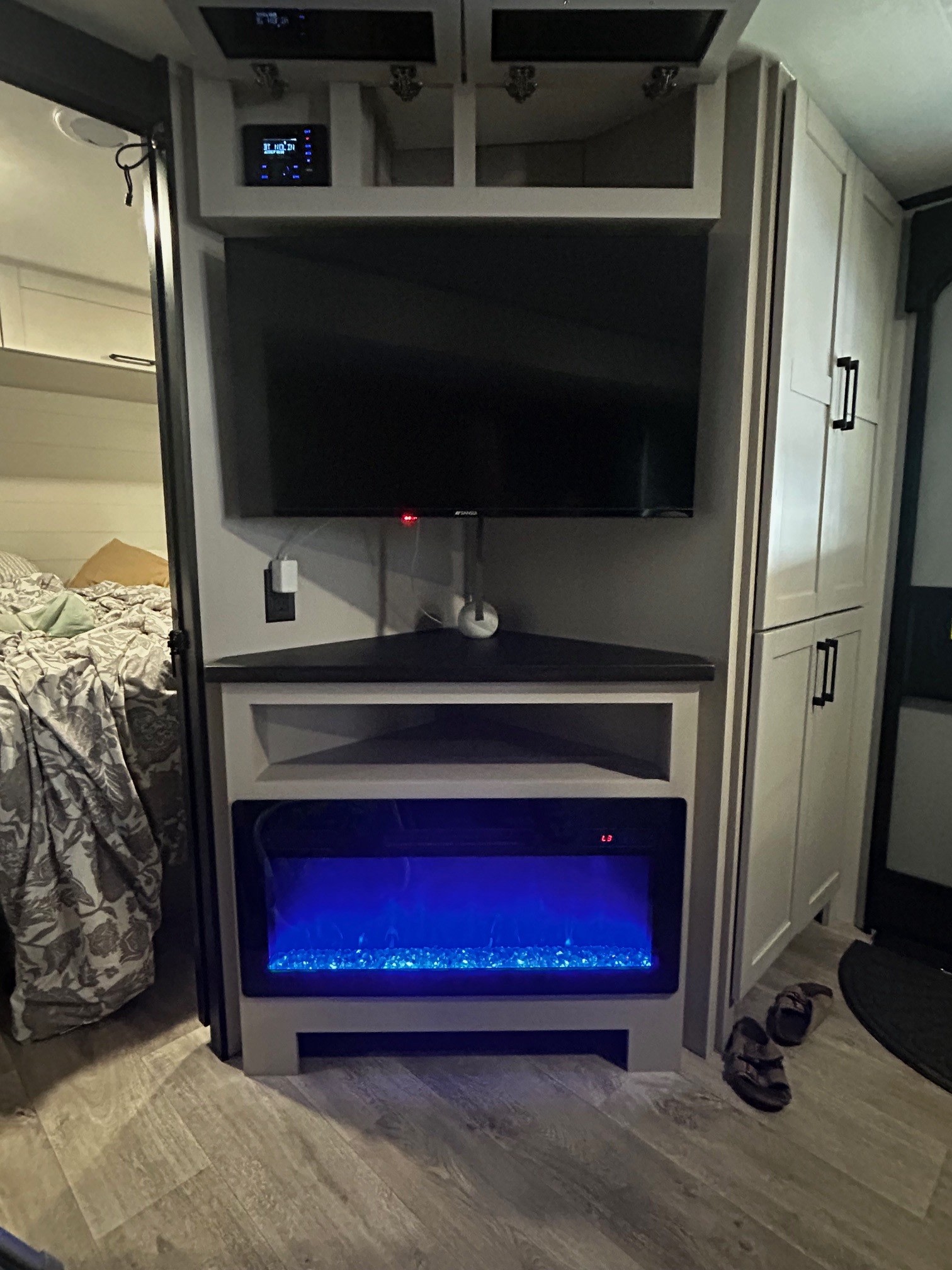 Modern RV rental interior: Corner entertainment unit featuring a TV, glowing blue electric fireplace, and stereo system.. Jayco 29BHB 2026