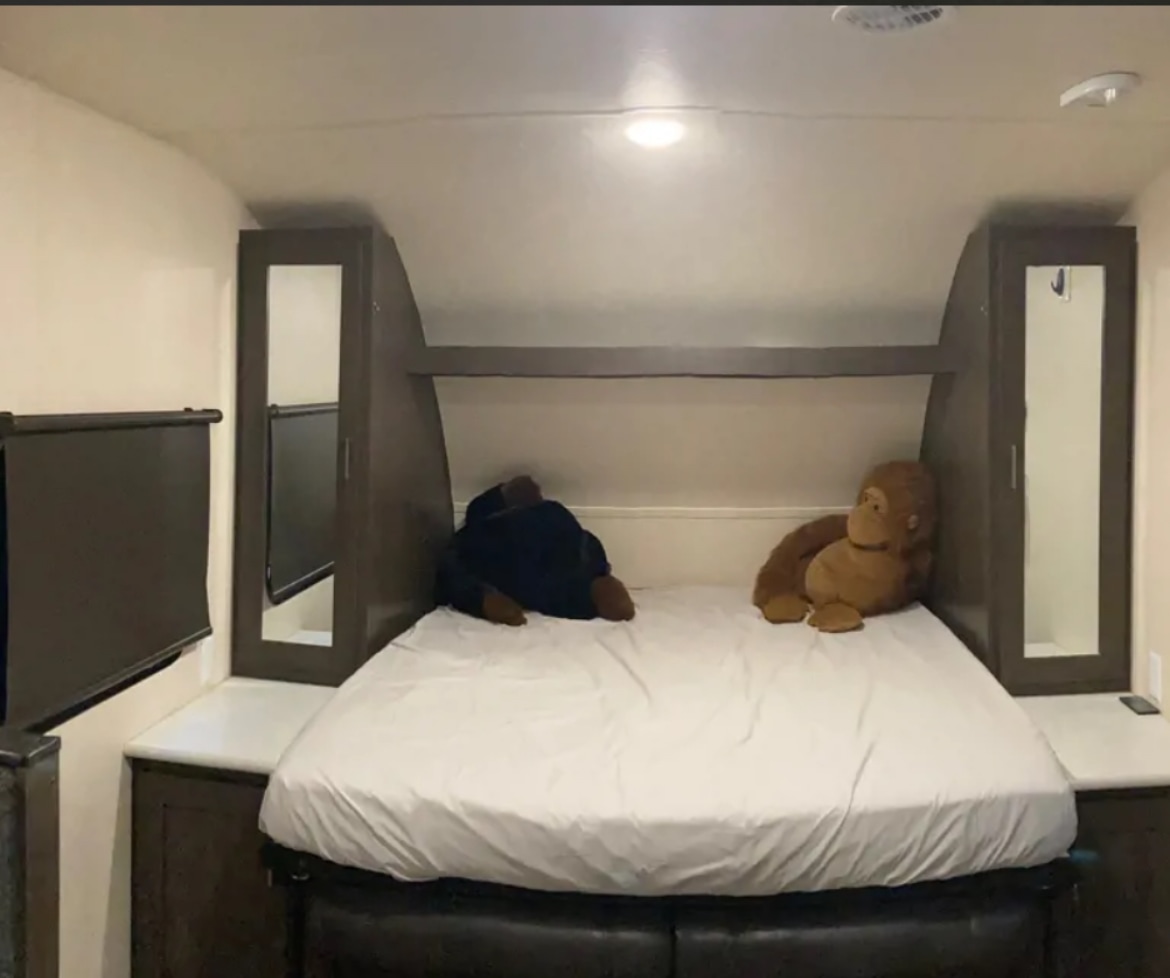 Cozy RV rental bedroom featuring a bed with two large stuffed animals, mirrored cabinets, and a TV for comfort.. Forest River Salem Cruise Lite 2019
