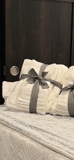 Fresh, neatly folded towels with grey ribbons, ready for your comfortable RV rental stay.. Jayco Pinnacle 2023