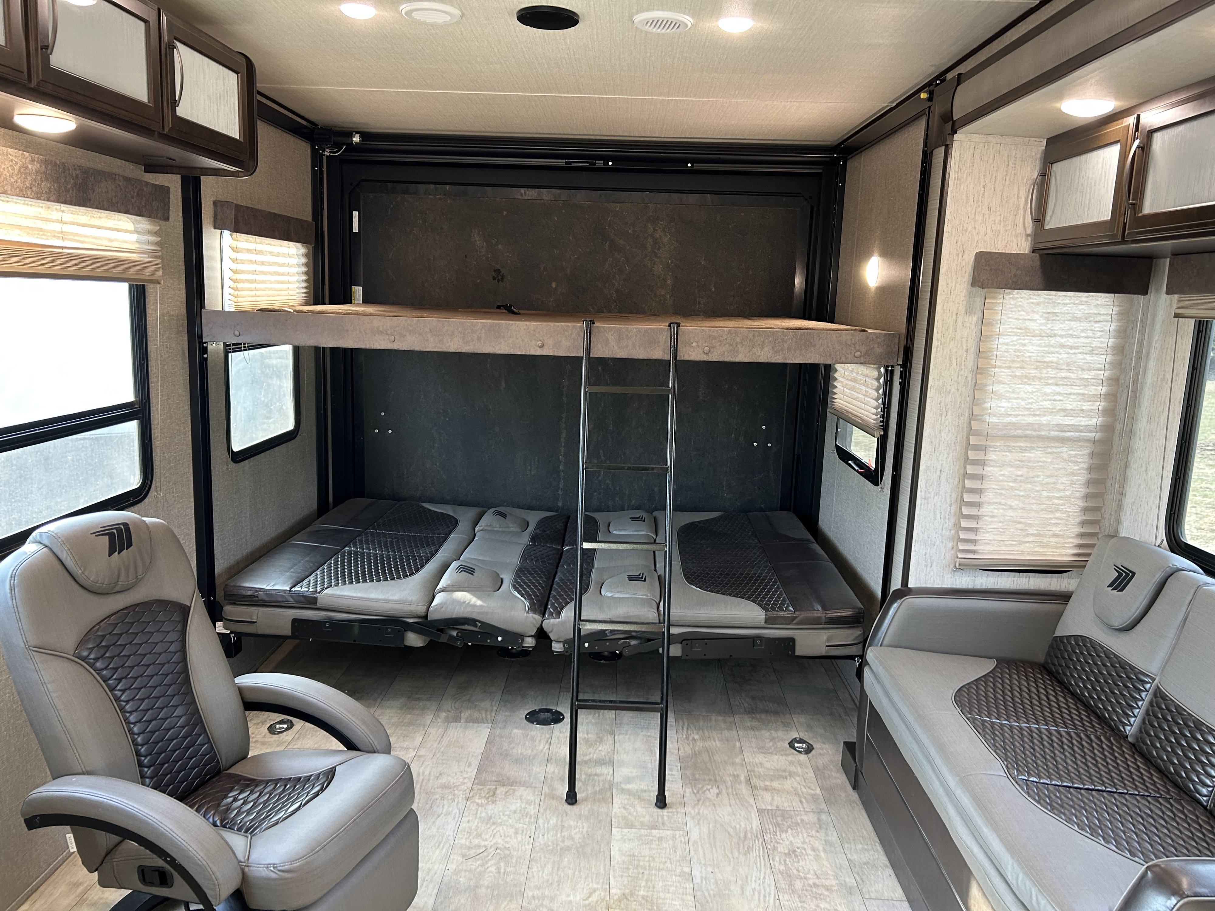 Modern rv rental interior with bunk beds, ladder, and plush grey seating/sofa. A versatile living space for your adventure.. Grand Design Momentum 2020