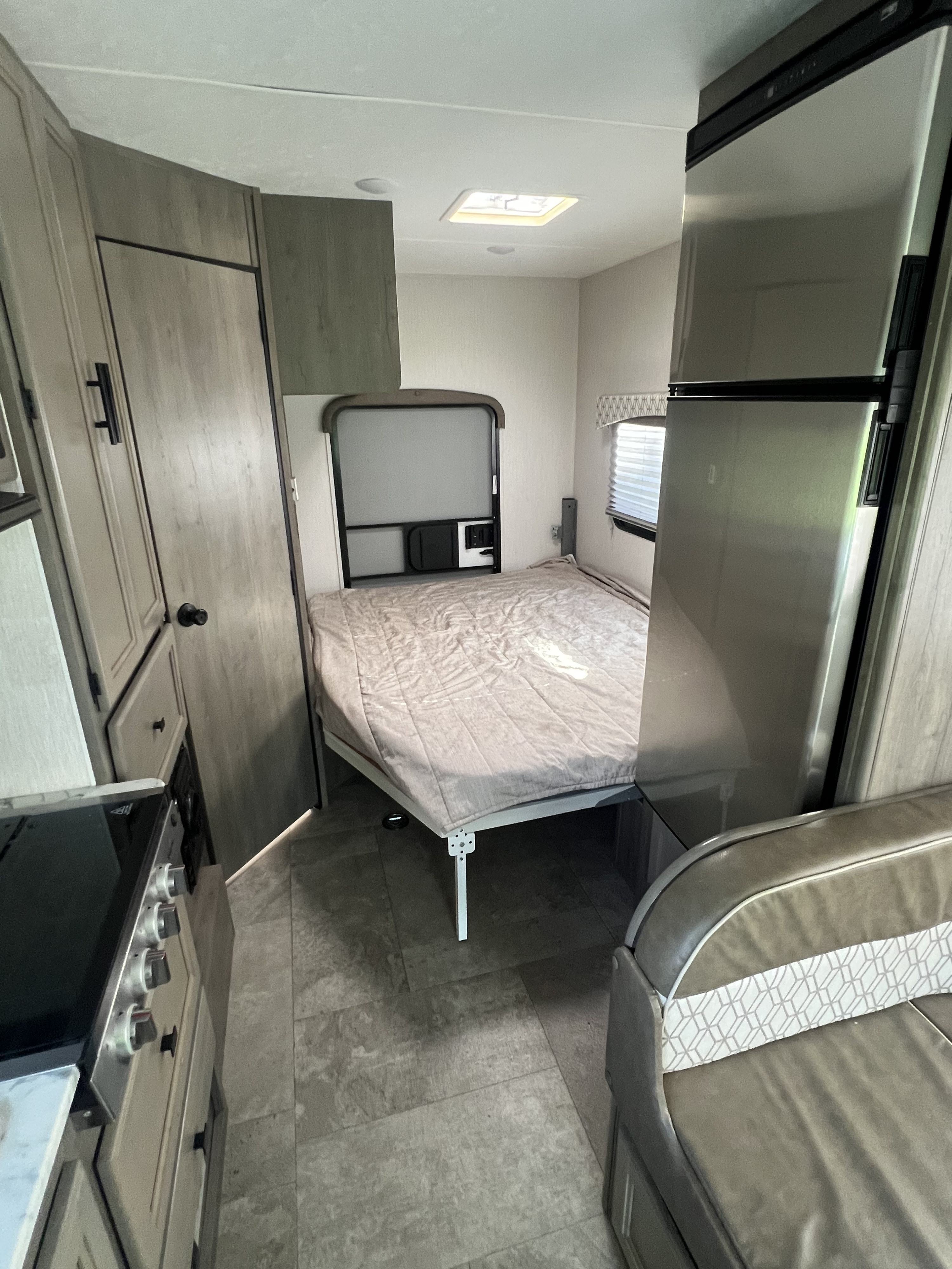 RV rental interior: a compact space featuring a fold-down bed, integrated kitchen with stove/fridge, and a comfy dinette.. Coachmen Freelander 22xg 2020