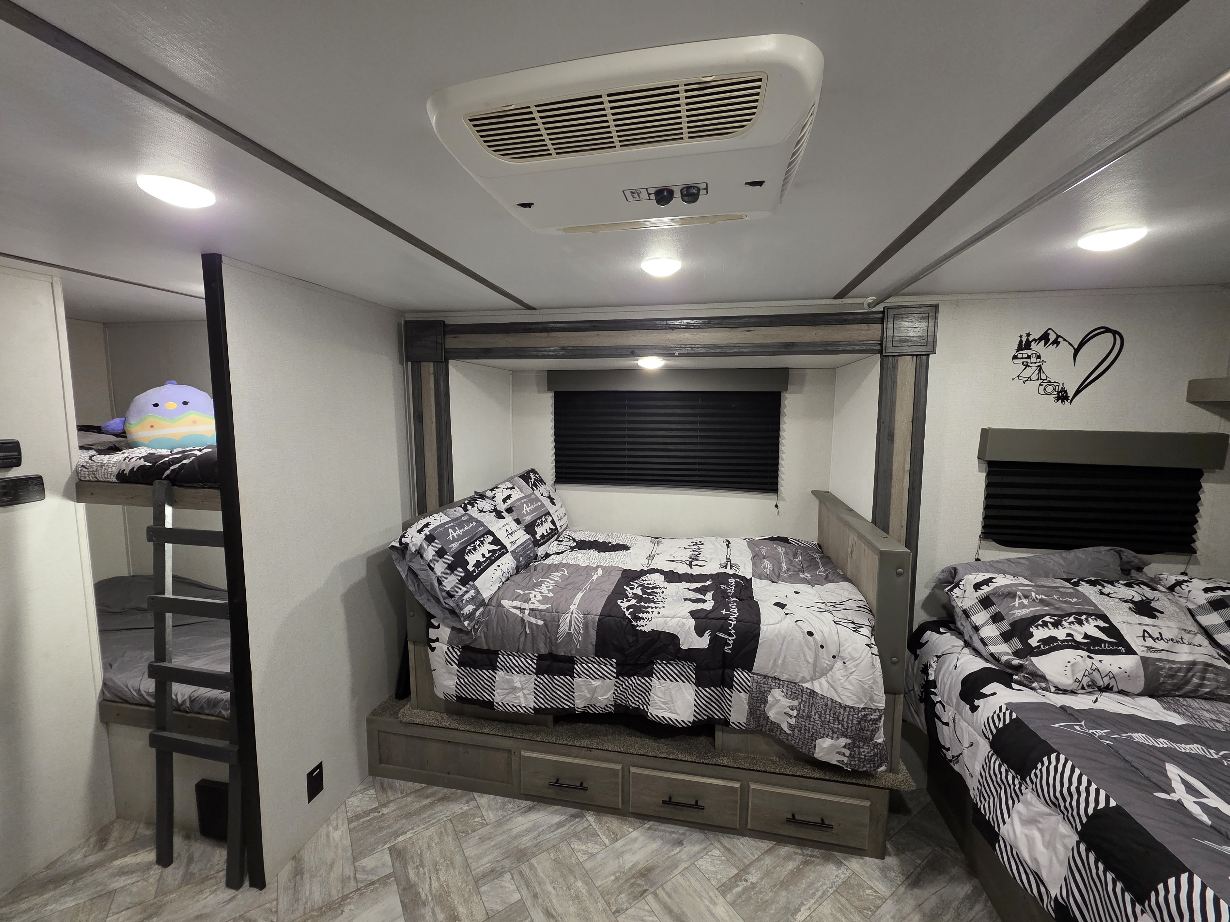 Cozy RV rental with a family-friendly sleeping area: main bed, bunk beds, and storage. Ideal for travel trailer adventures!. Keystone RV Springdale 2021