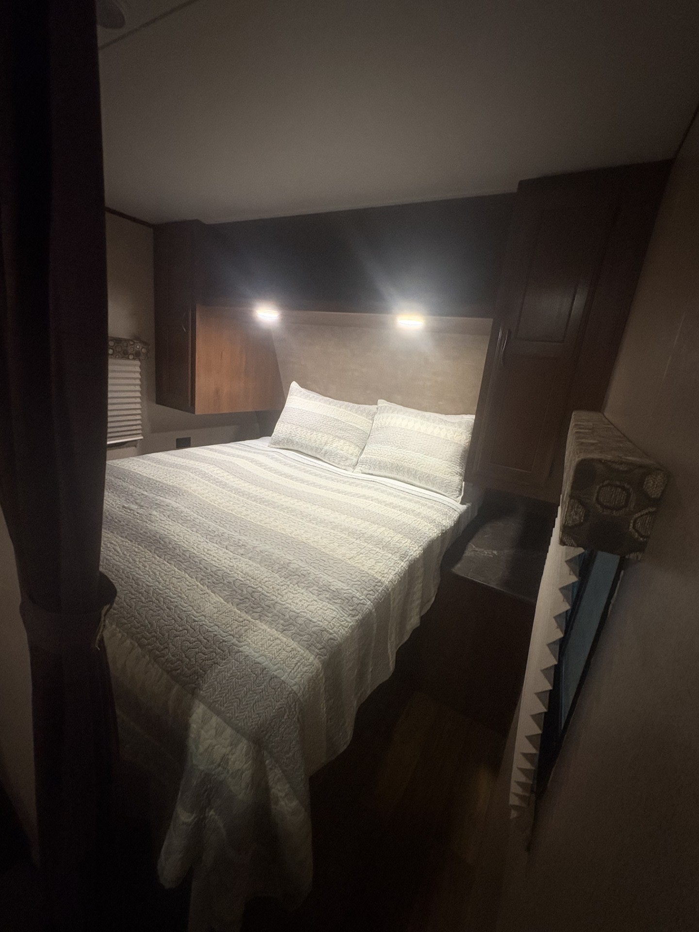 Cozy RV rental bedroom with a neatly made bed, pillows, and bright overhead reading lights for comfort.. Jayco Jay Flight 2015