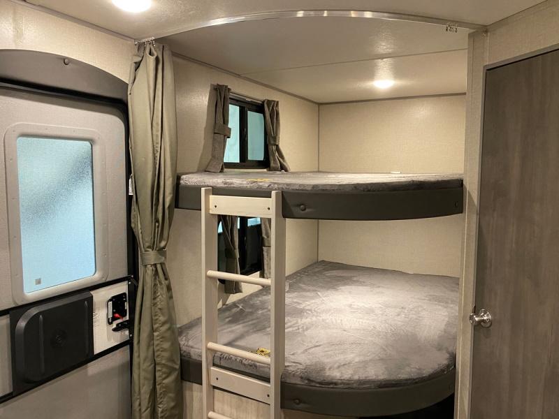 Cozy RV rental interior showing bunk beds with grey bedding and a ladder next to the entrance. Perfect for family adventures.. Coachmen catalina 2022