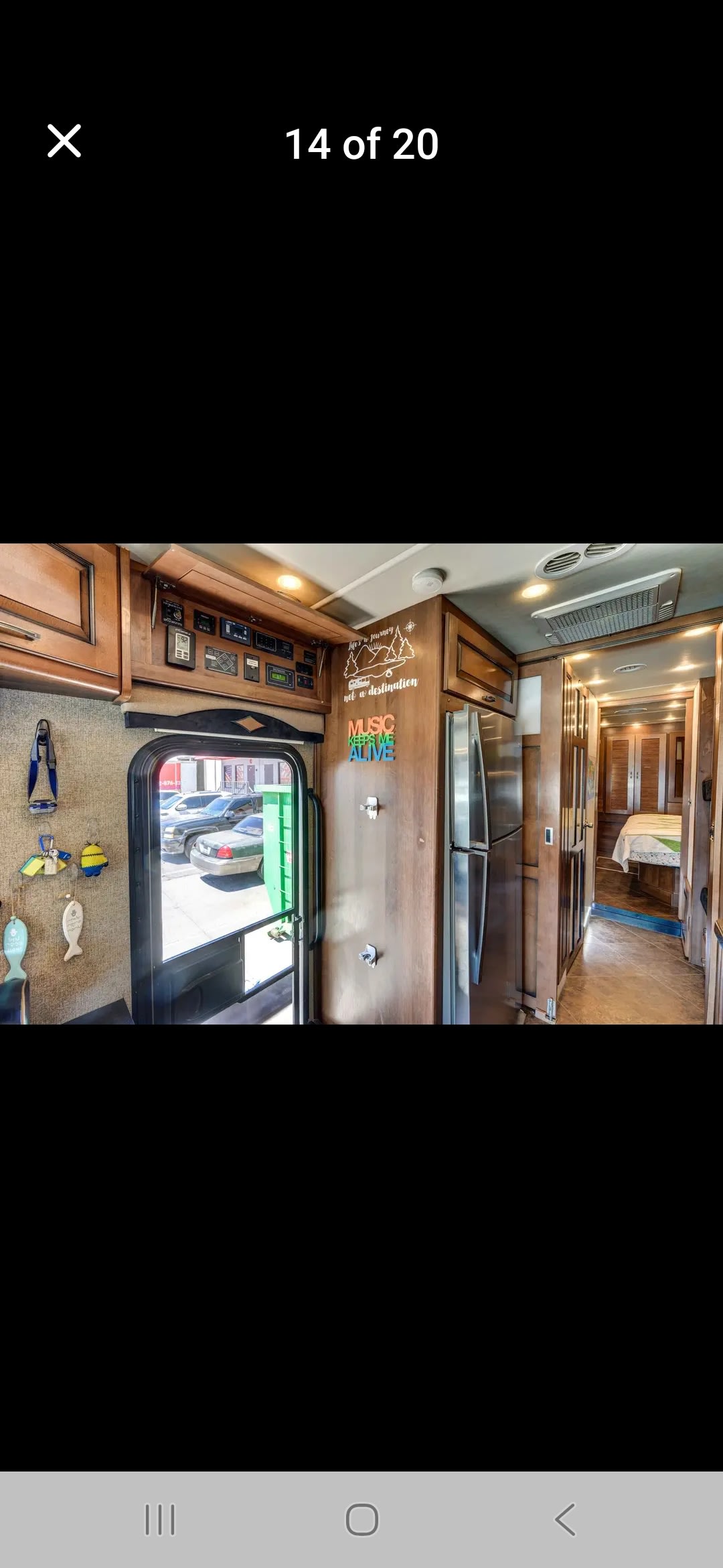 Inside an rv rental: Looking from the entry door, past kitchen, fridge, and into the bedroom area with personalized decor.. Fleetwood Excretion 2015
