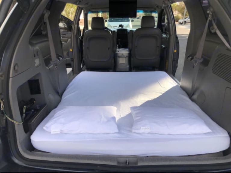 Minivan RV rental: Cozy interior with mattress & pillows, perfect for comfortable road trip sleeping or van life adventures.. Toyota Other 2008