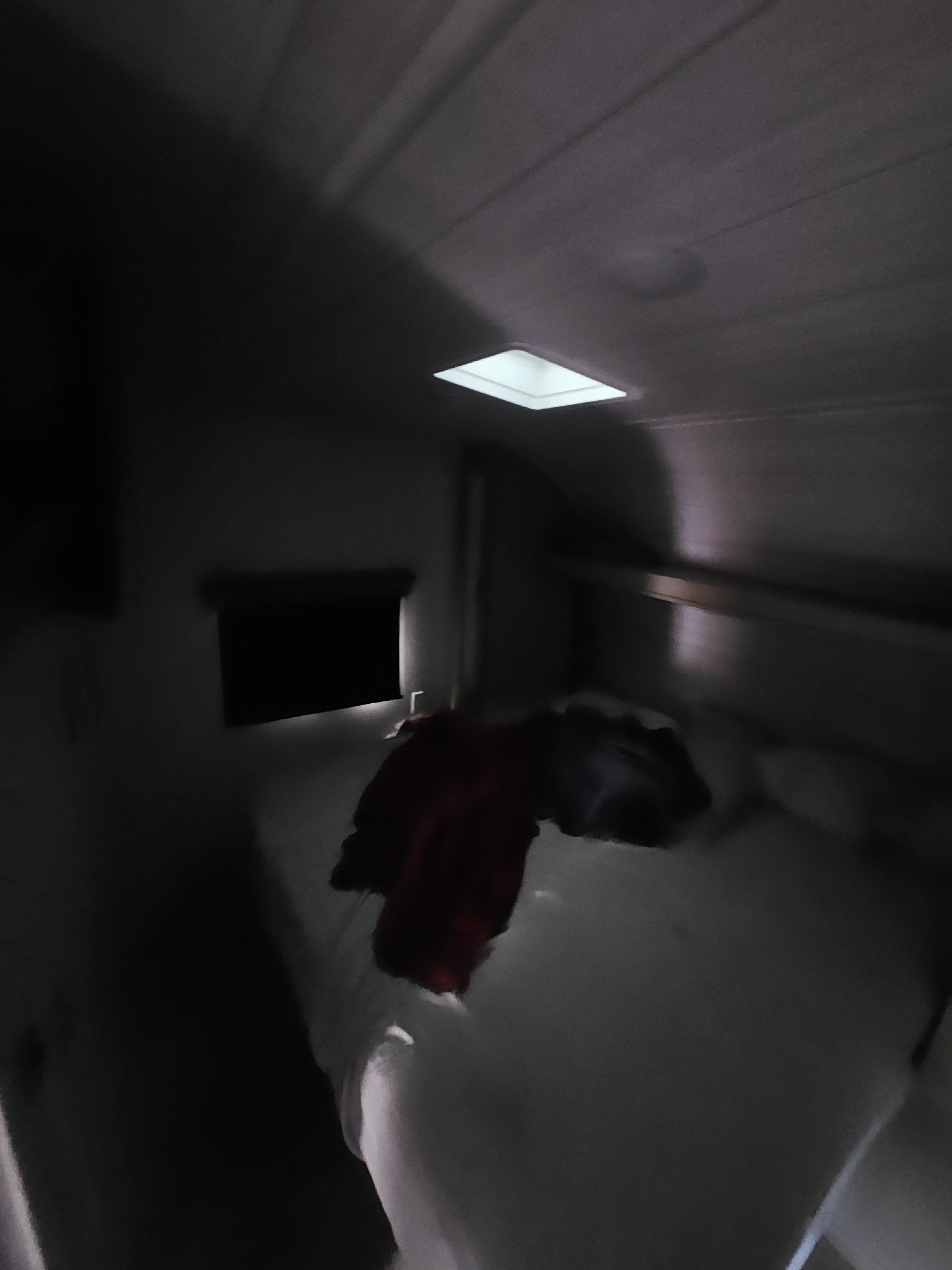 Dim RV rental bedroom, with clothes on the bed and a ceiling light. A cozy and compact space for your travel adventure.. Forest River Sandstorm 2023