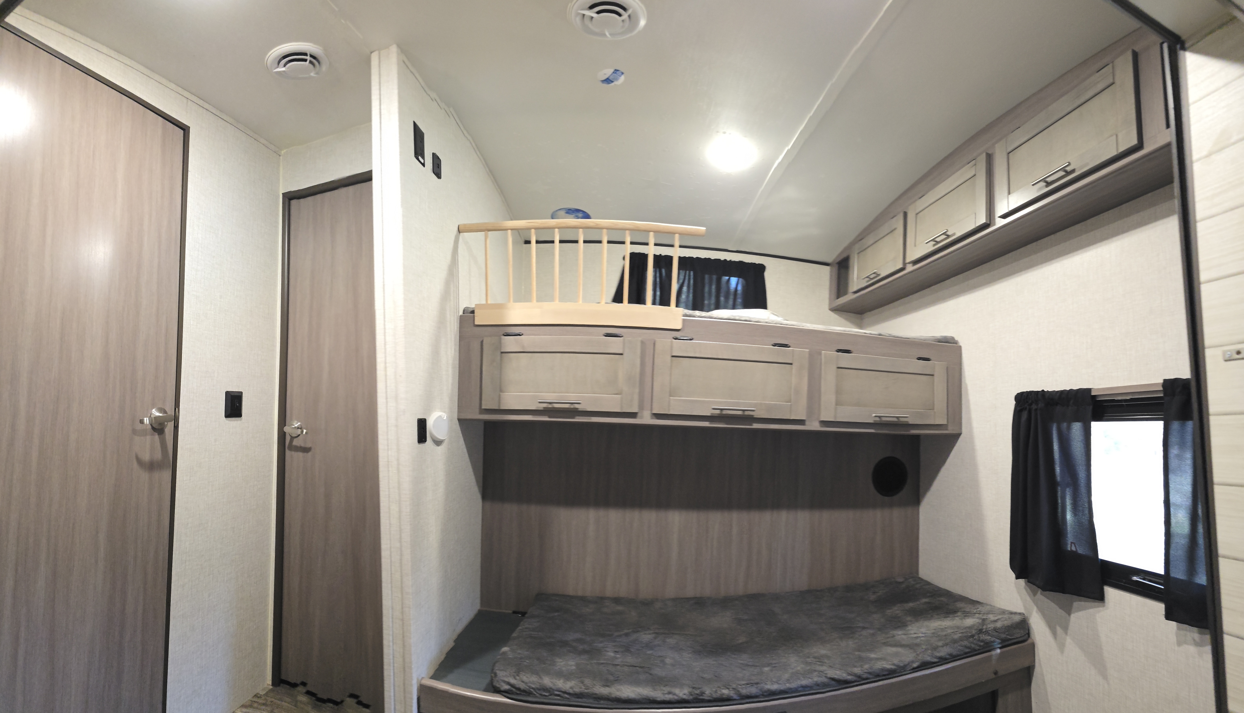 Inside this RV rental: comfortable bunk beds with a safety rail, storage cabinets, and a window. Ideal for family adventures.. Crossroads RV Sunset Trail 2022