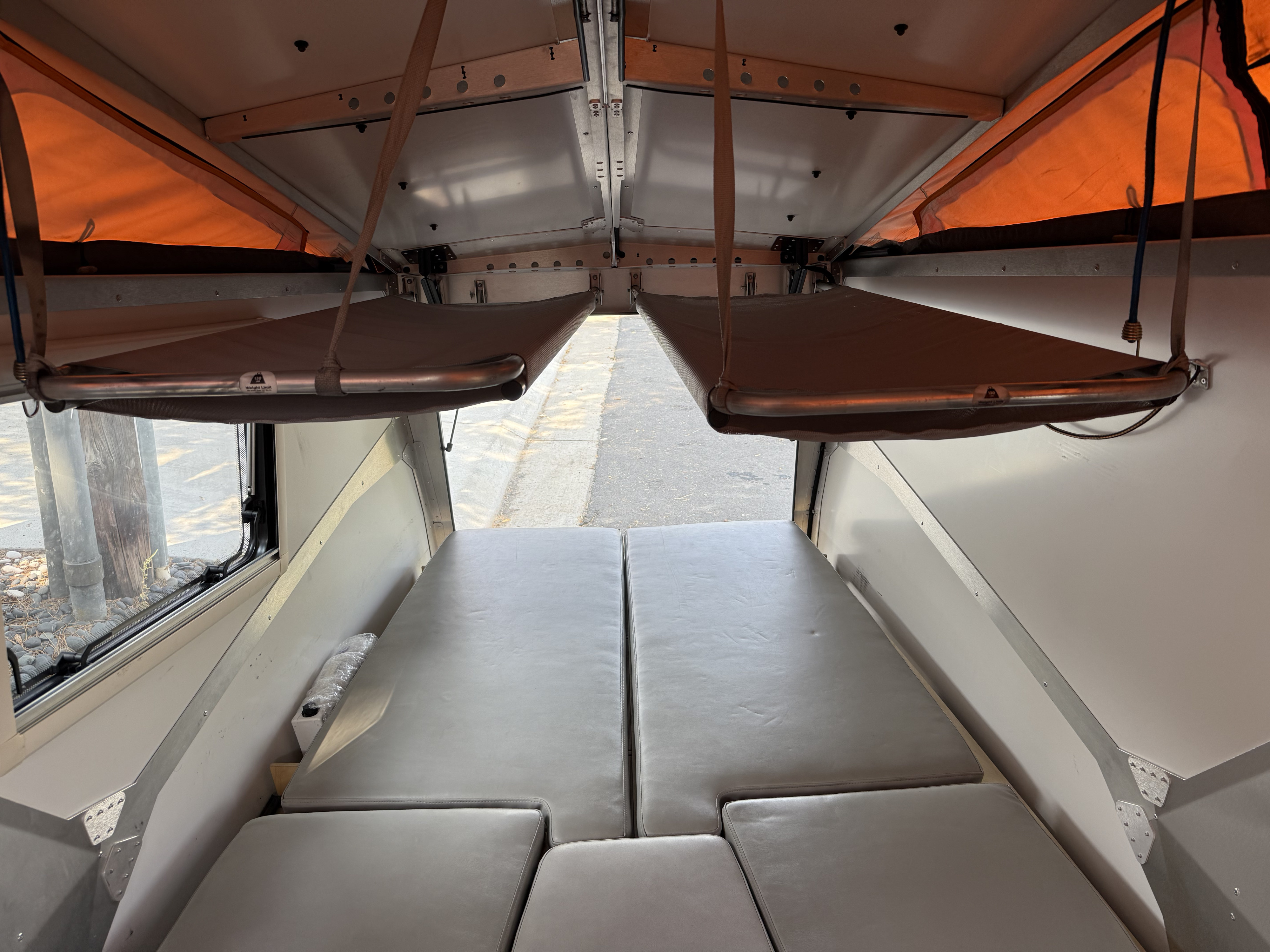 RV rental interior: pop-top camper with modular bed/seating and two suspended bunks. Spacious & versatile.. TAXA TAXA Trailer 2016