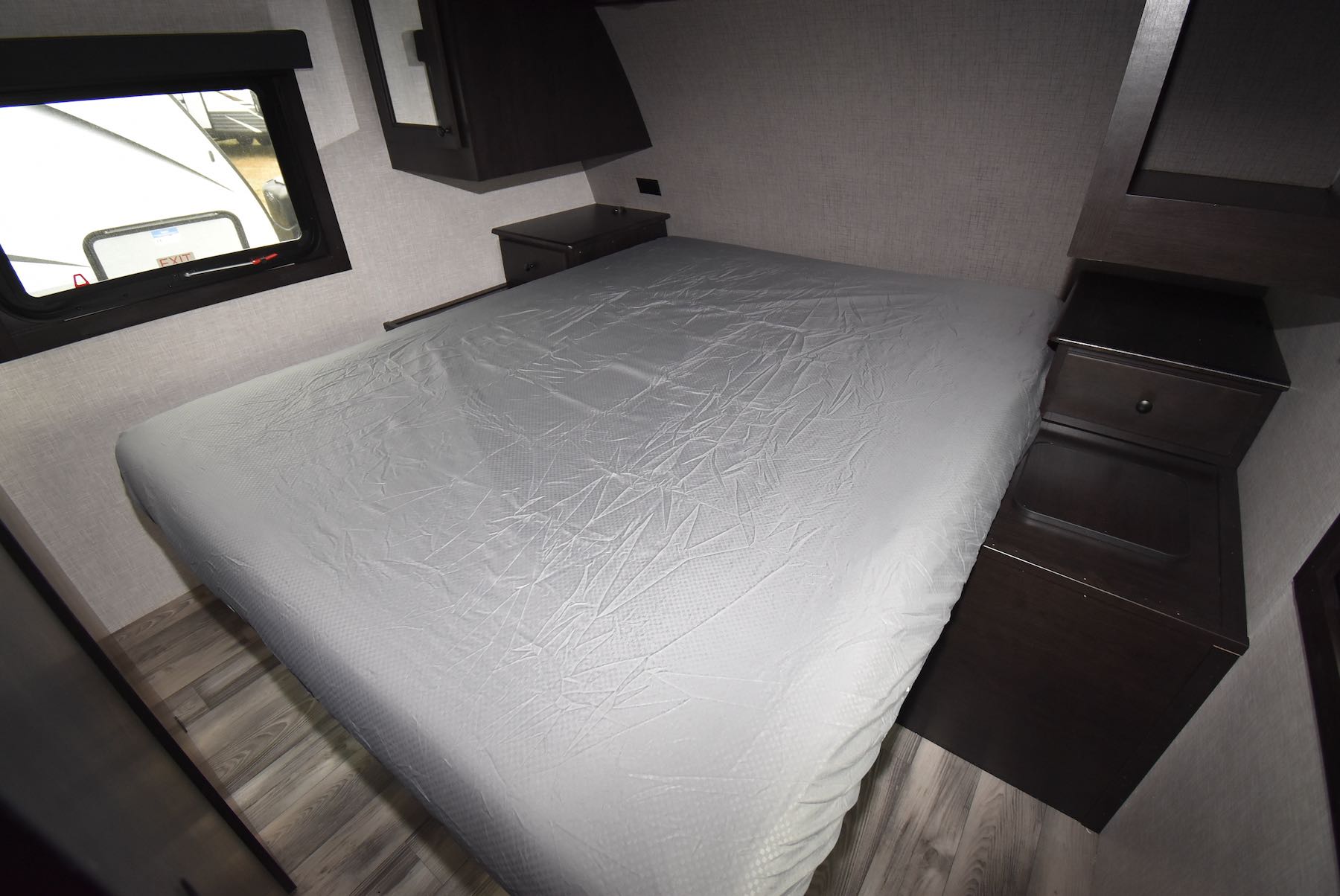 Comfortable RV rental bedroom featuring a large bed, window, and integrated side storage cabinets. Ideal for camper travel.. Starcraft Super Lite 2023