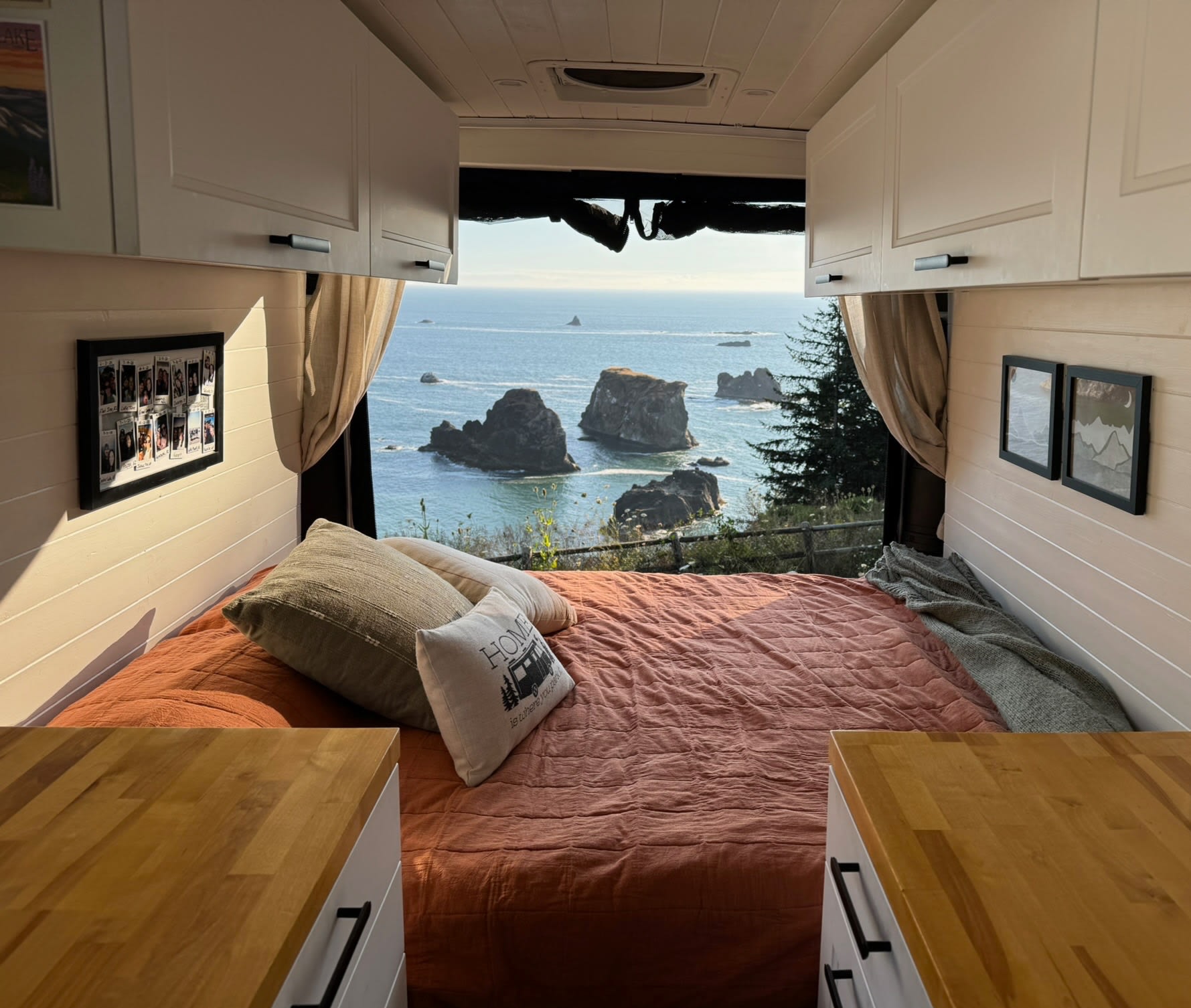 Cozy RV rental bedroom with a spectacular ocean view of sea stacks. A comfortable bed offers a stunning natural backdrop.. Dodge Ram ProMaster 2500 2021