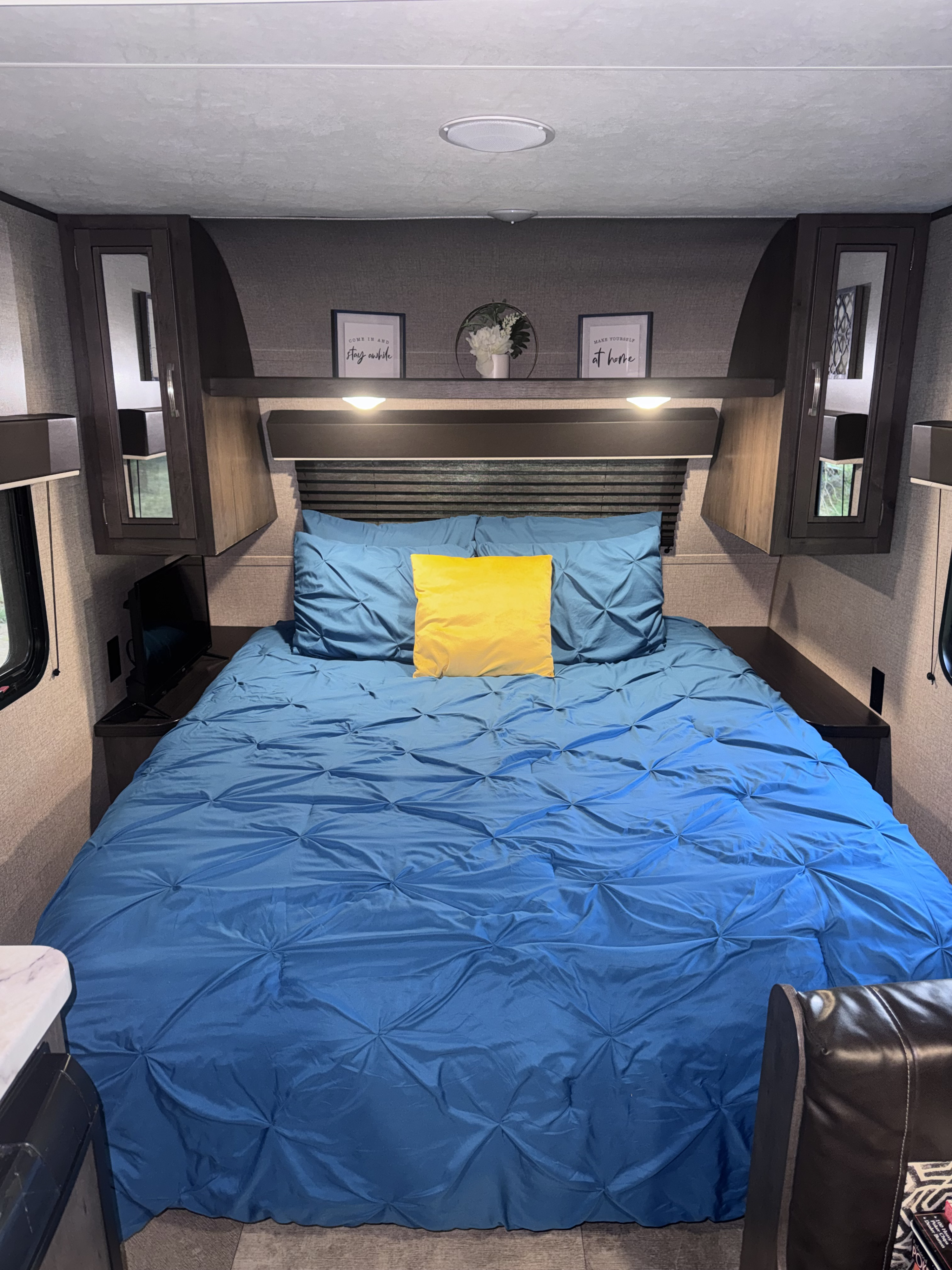 Cozy RV rental bedroom with a blue bed, yellow pillow, and inviting decor. Perfect for a comfortable travel stay.. Jayco Jay Flight SLX 2020
