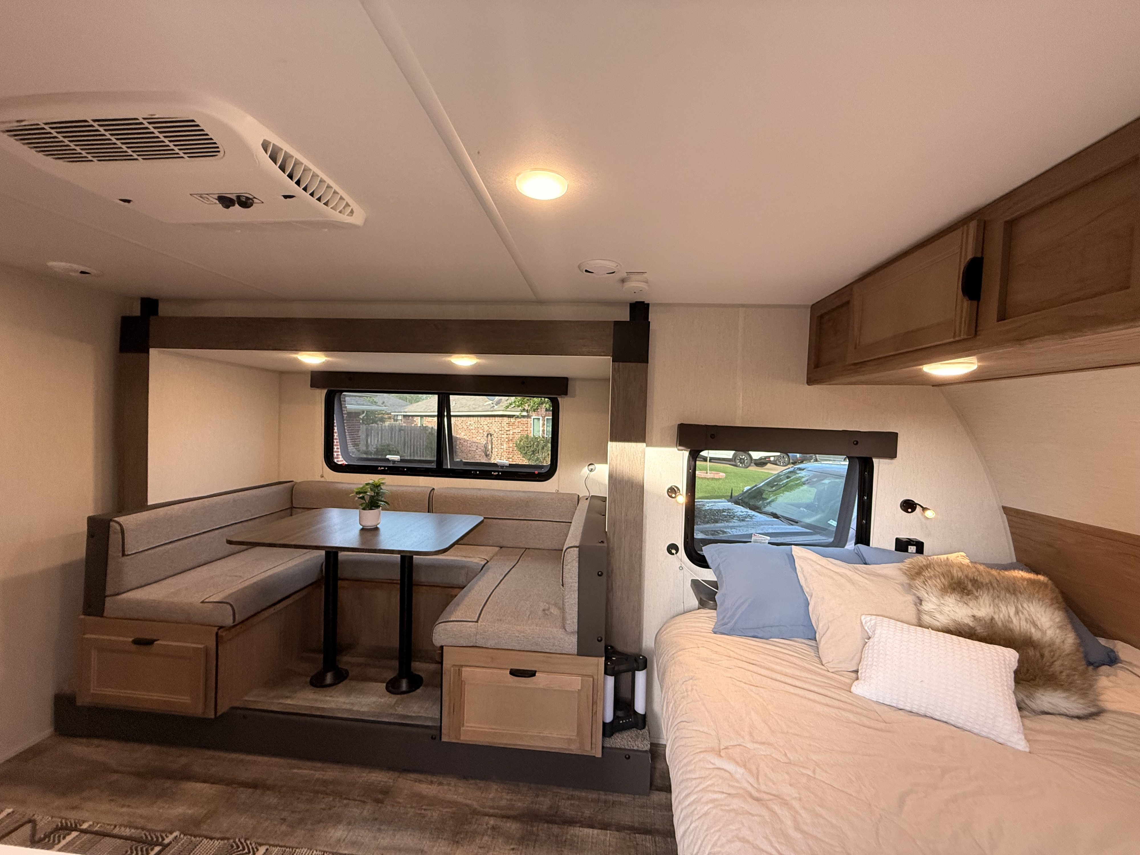 Explore this inviting rv rental interior featuring a comfy bed, functional dinette with storage, and bright windows.. Forest River Cherokee Wolf Pup Black Label 2024