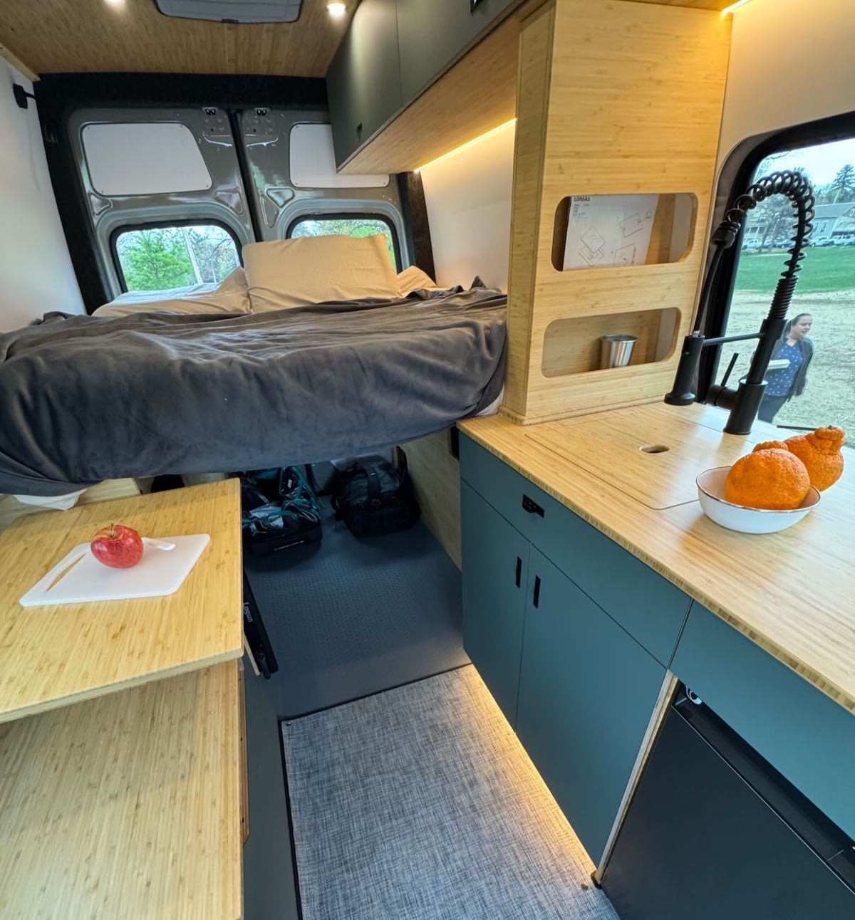 This compact RV rental interior features a raised bed, full kitchen with sink, and under-bed storage for mobile adventures.. Mercedes Sprinter 2500 2026