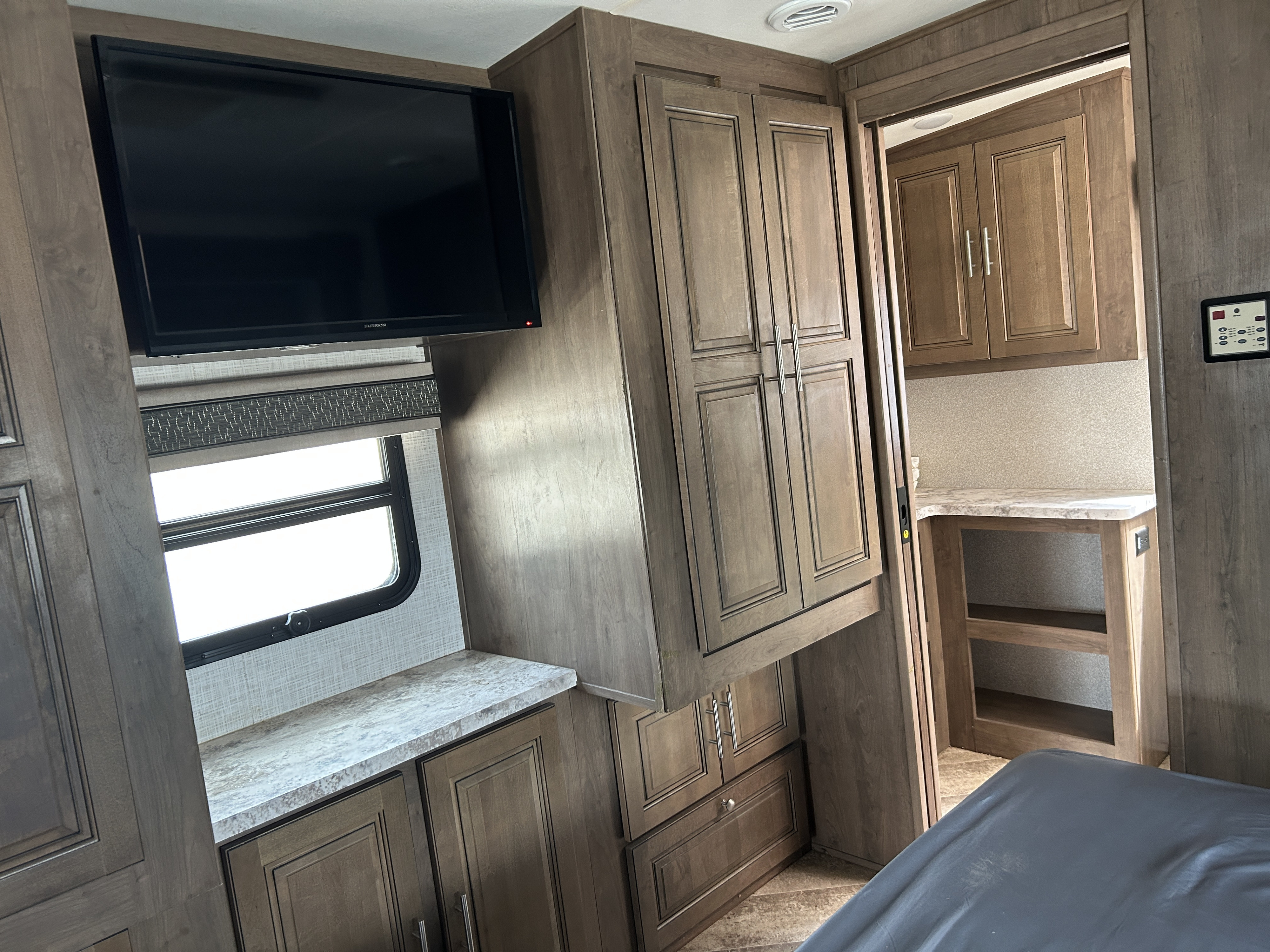 Spacious RV rental interior with TV, ample cabinets, and a cozy bedroom setup, ideal for your next adventure.. Forest River Georgetown 2019