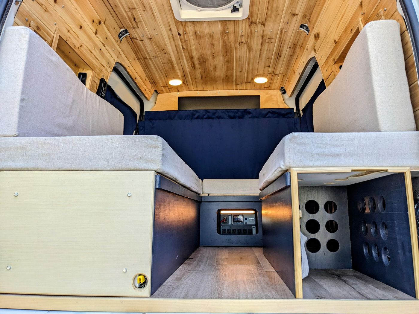 Step into this RV rental camper van: wood-paneled ceiling, cushioned benches/beds, and a lit control panel. Cozy mobile living!. Ford Transit 2013