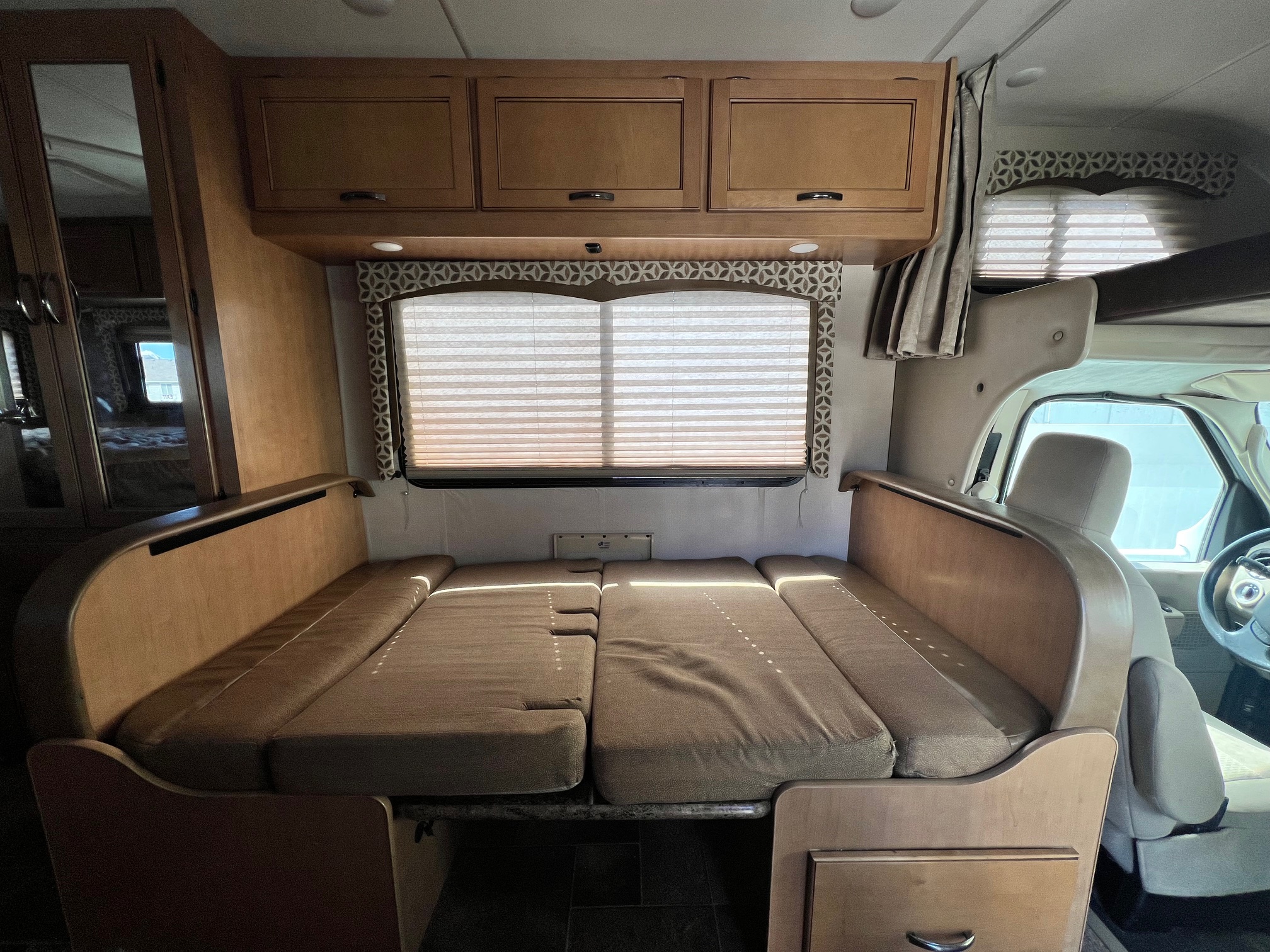 RV rental interior: Dinette converts to a cozy bed, with overhead cabinets and window blinds visible. Perfect for a road trip.. Thor Four Winds 2016