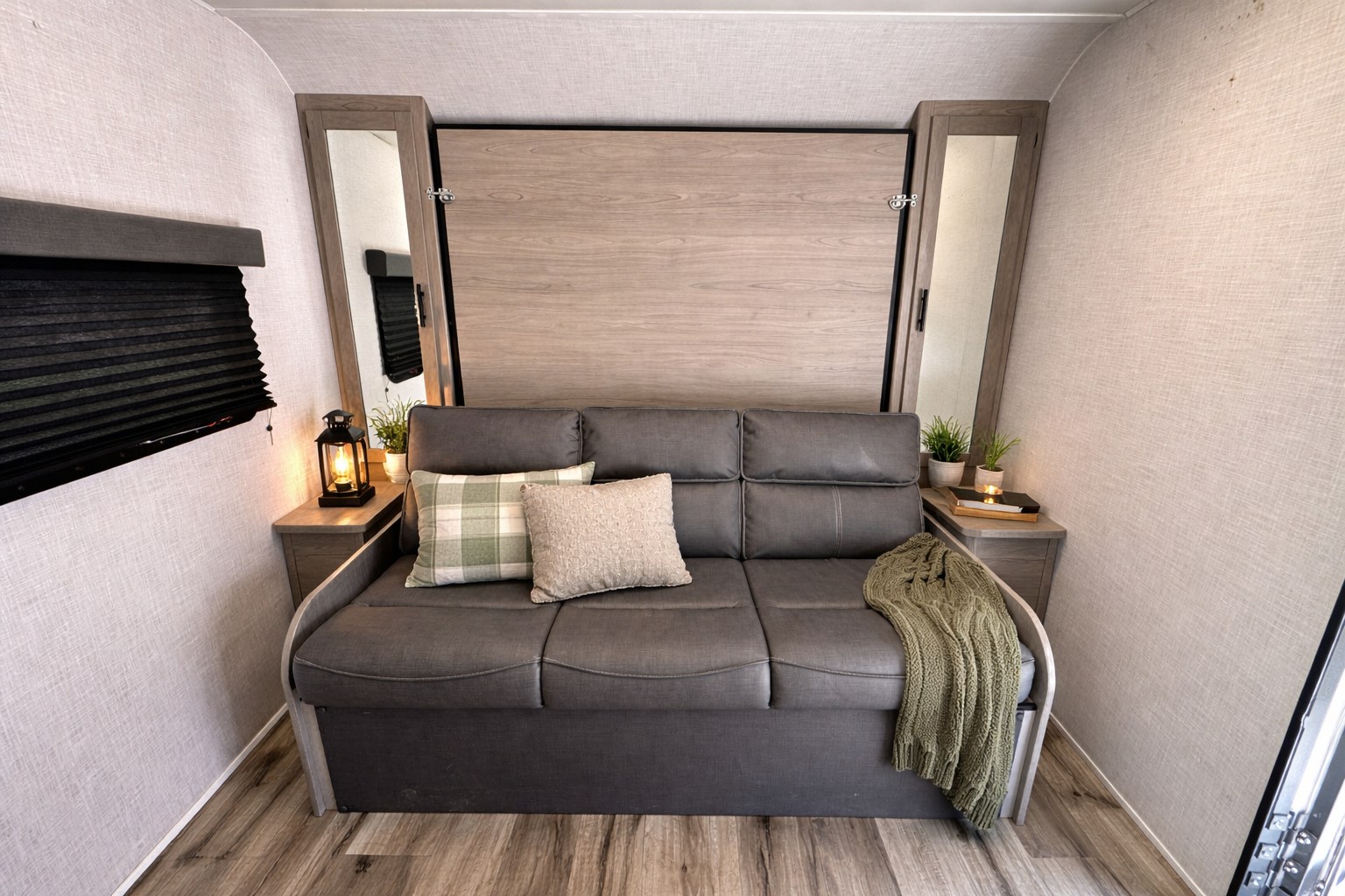 Cozy RV rental interior with a gray sofa, murphy bed, and decorative touches, ready for your next adventure.. Dutchmen Coleman 2022