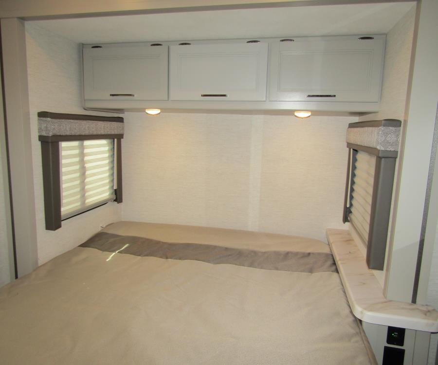 Cozy RV rental bedroom with storage cabinets, window blinds, and a comfortable bed. Perfect for travel accommodation.. Thor Chateau 2025