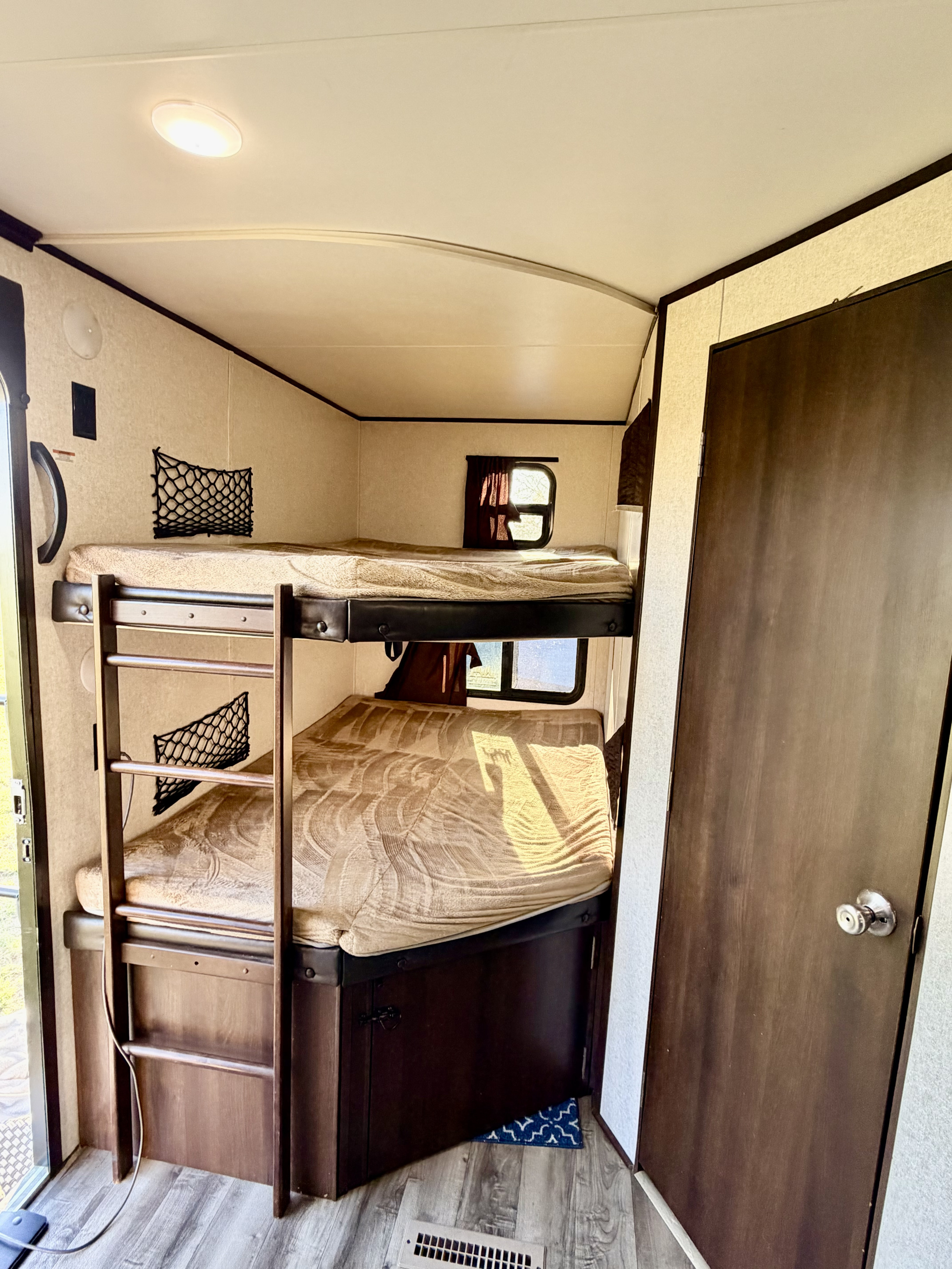 Cozy bunk beds inside an RV rental, complete with a ladder, windows, and ceiling light—perfect for family camping.. Jayco Jay Flight 2018