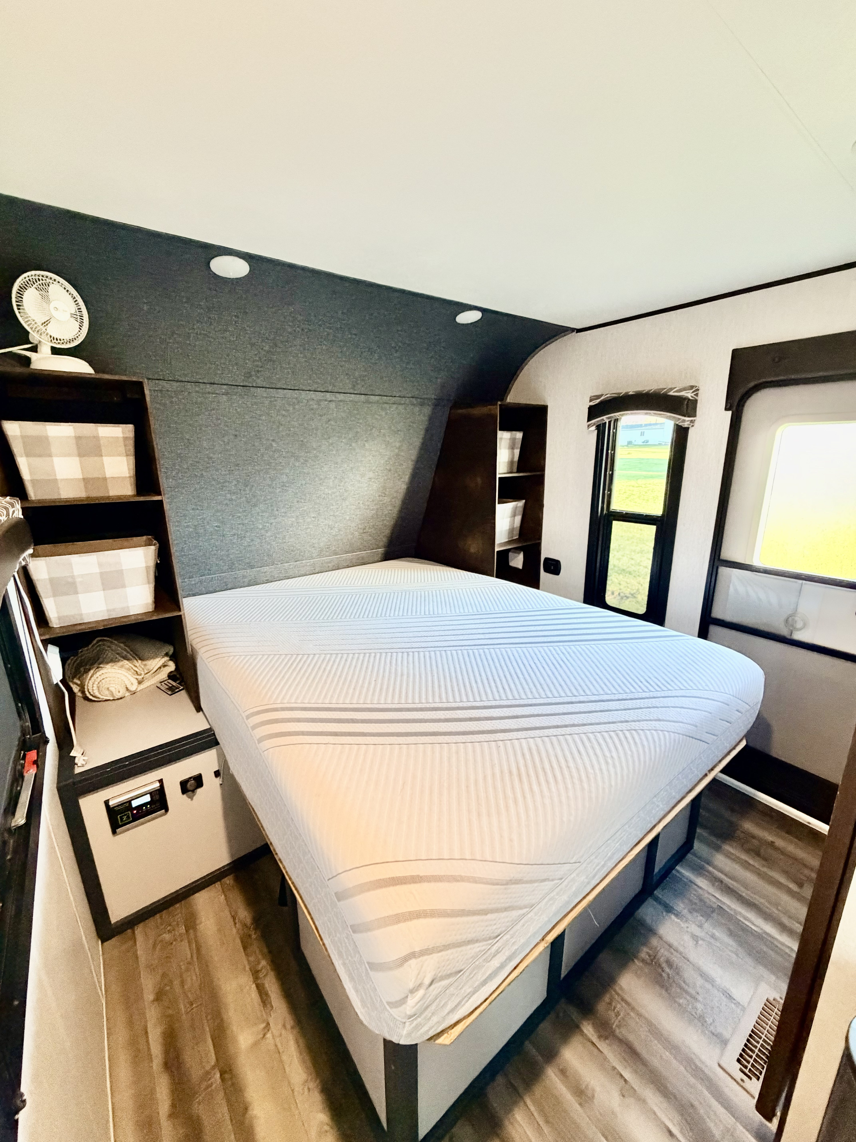 Comfy RV rental bedroom: Features a large bed, built-in storage, a fan, and scenic views from the window.. Jayco Jay Flight 2018