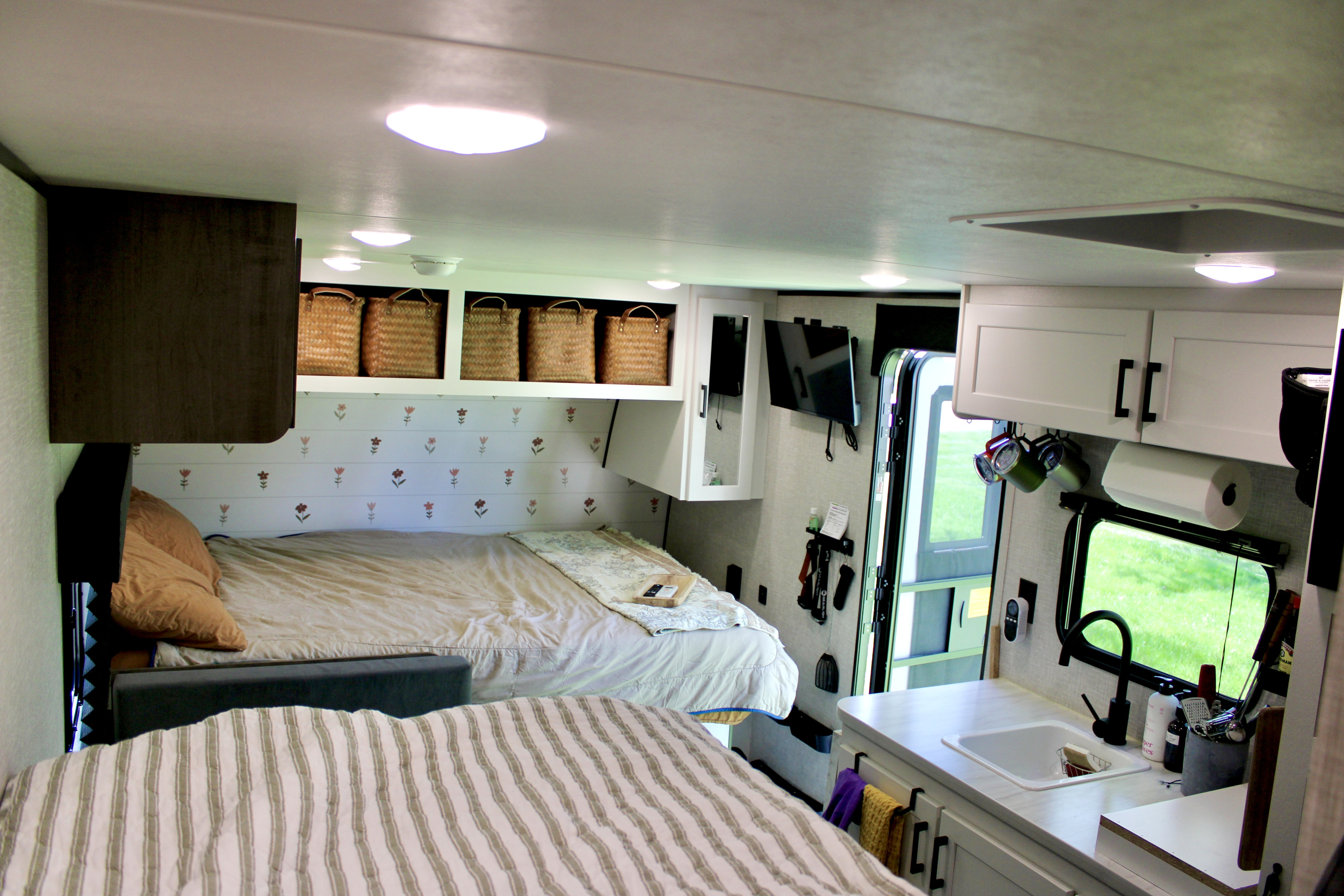 Modern rv rental interior with bunk beds, a neat kitchen sink area, and woven storage baskets. Ready for your travels!. Jayco Jay Flight SLX 2025