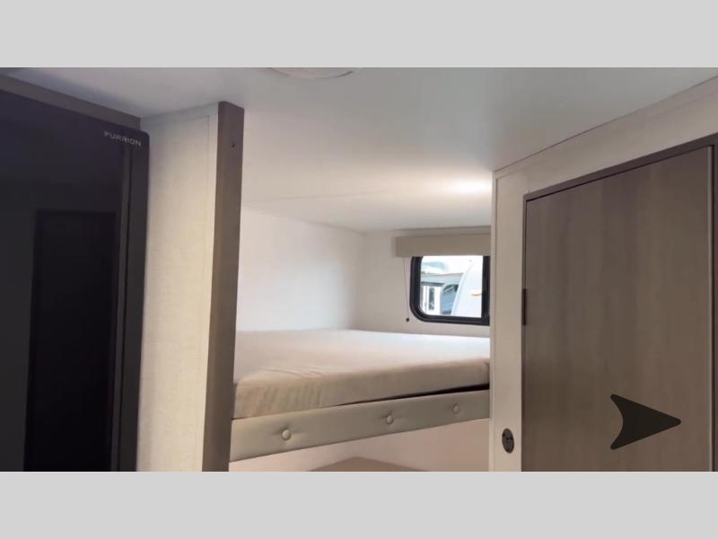 RV rental: Bunk beds, window, and Furrion appliance in a compact interior. Cabinet on right. Ideal for travel.. Grand Design Transcend One 2025