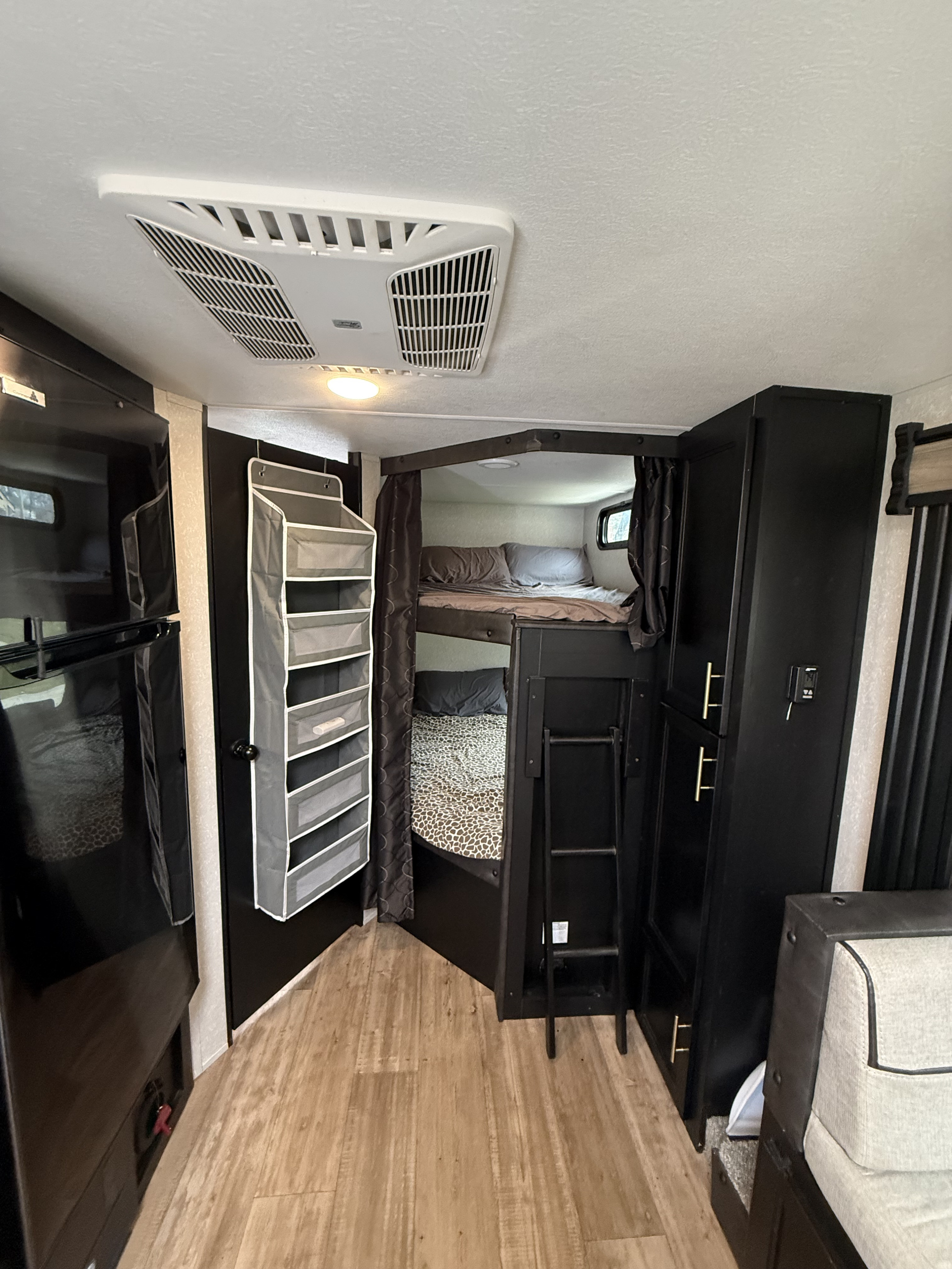 Cozy RV rental bunk beds with AC, storage, and modern dark interiors, perfect for family adventures.. Forest River Cherokee Grey Wolf 2022