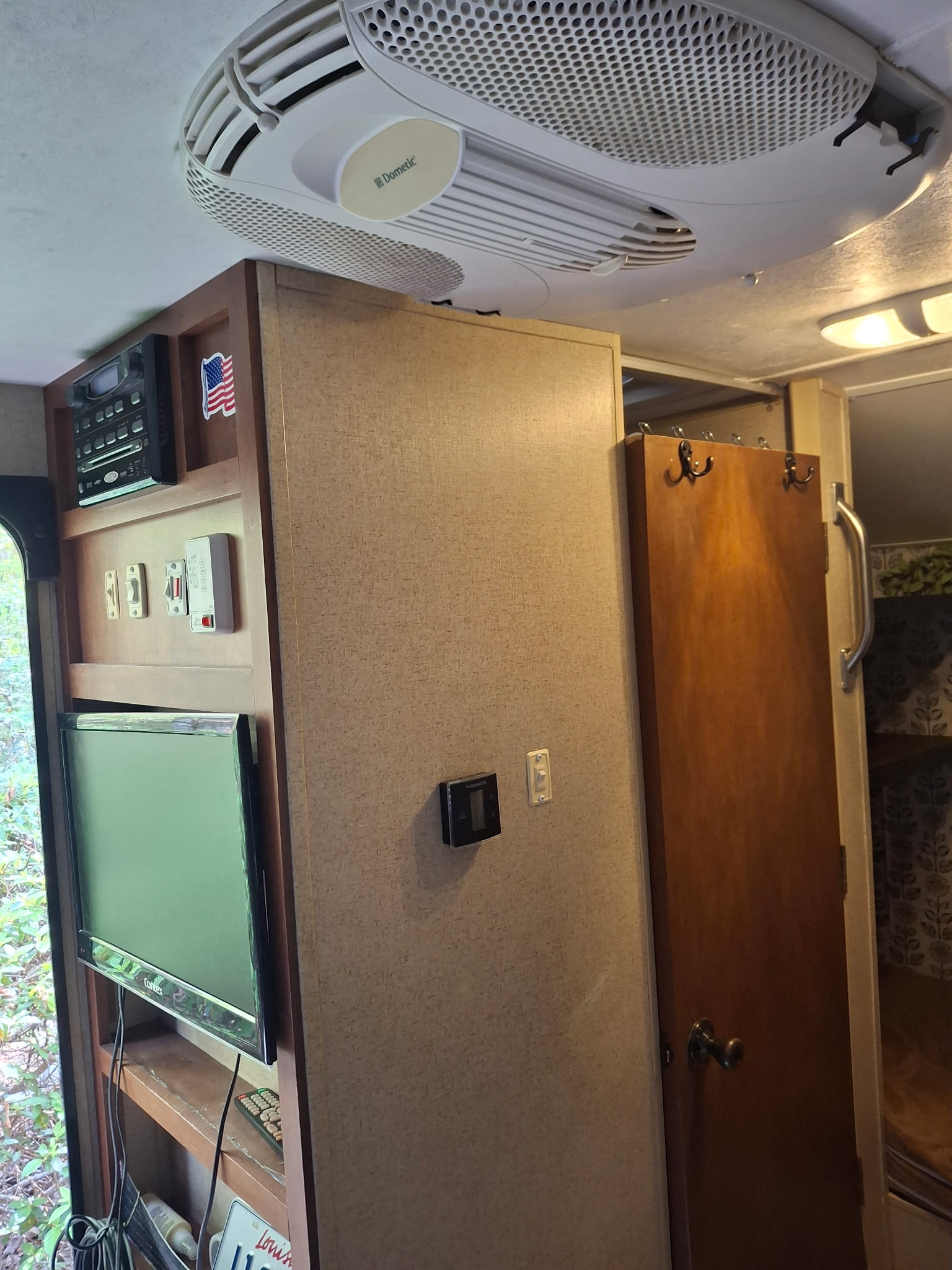 RV rental interior showcasing a Dometic AC unit, TV, stereo, control panel, and a glimpse of the bunk beds.. R-Pod R-Pod Trailer 2014