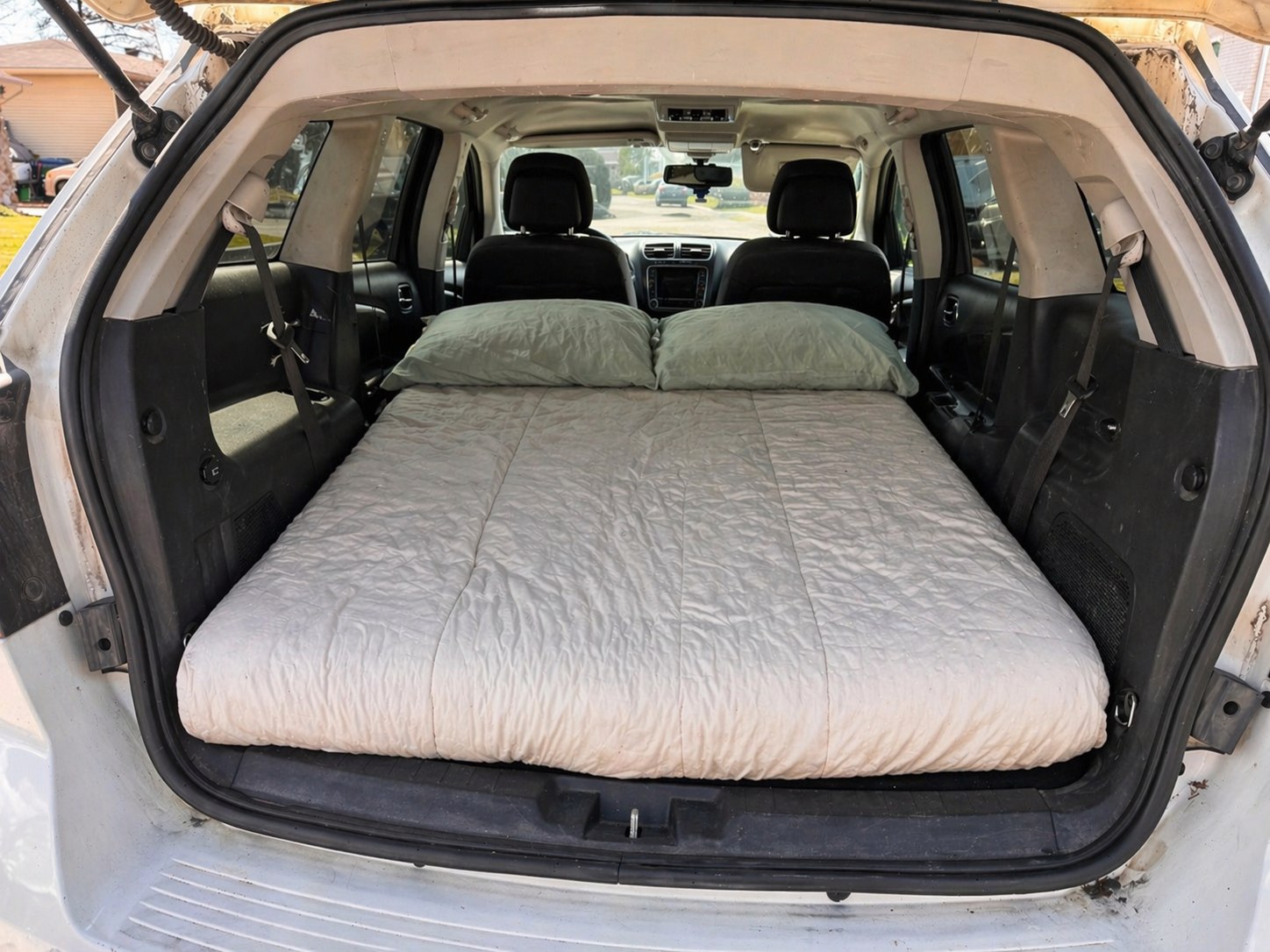 DIY RV rental for camping: a comfy bed set up in an SUV's trunk for road trips.. Dodge Journey 2012