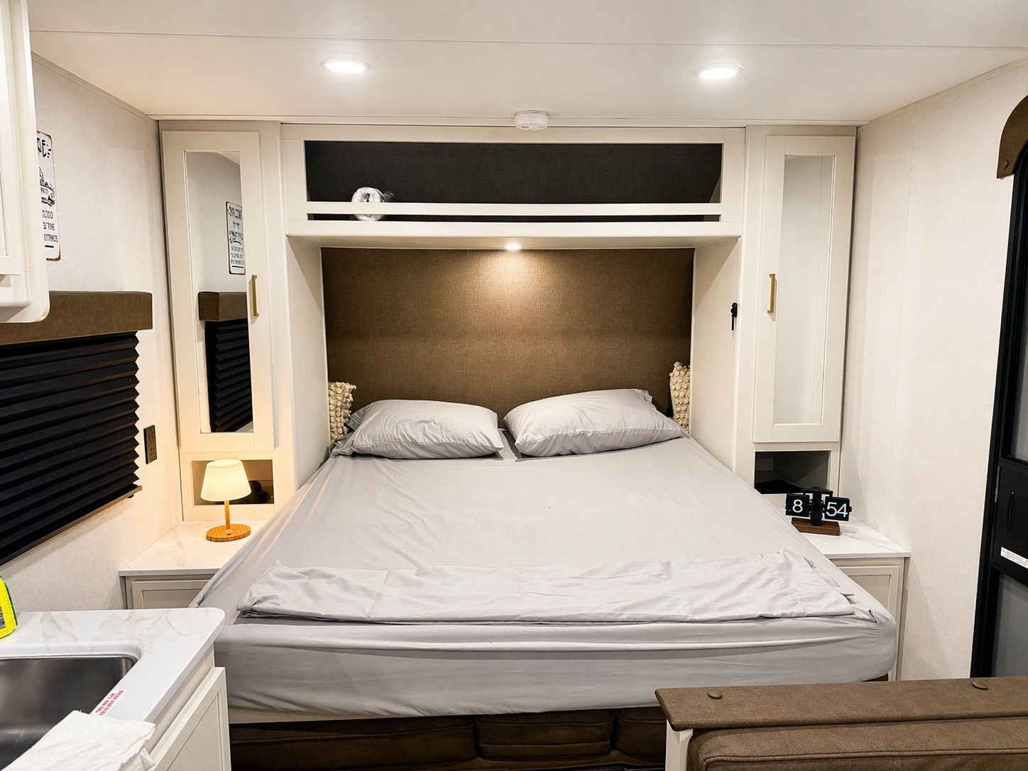 Cozy RV rental bedroom features a queen bed, built-in storage, and ambient lighting for a relaxing stay.. Grand Design Transcend 2026