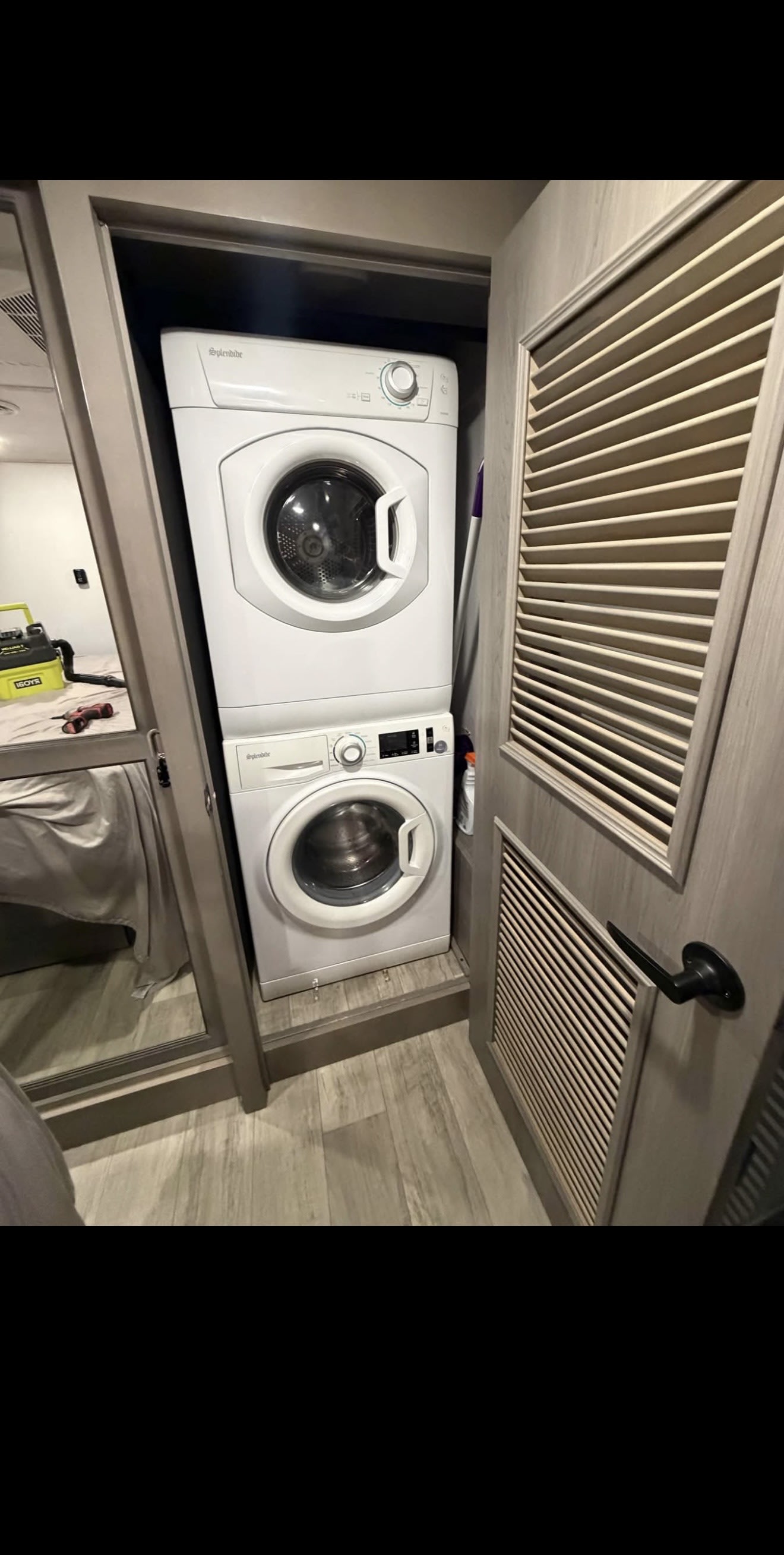 RV rental features a compact, white Splendide stacked washer and dryer, neatly built into a narrow utility space.. Keystone RV Montana 2022