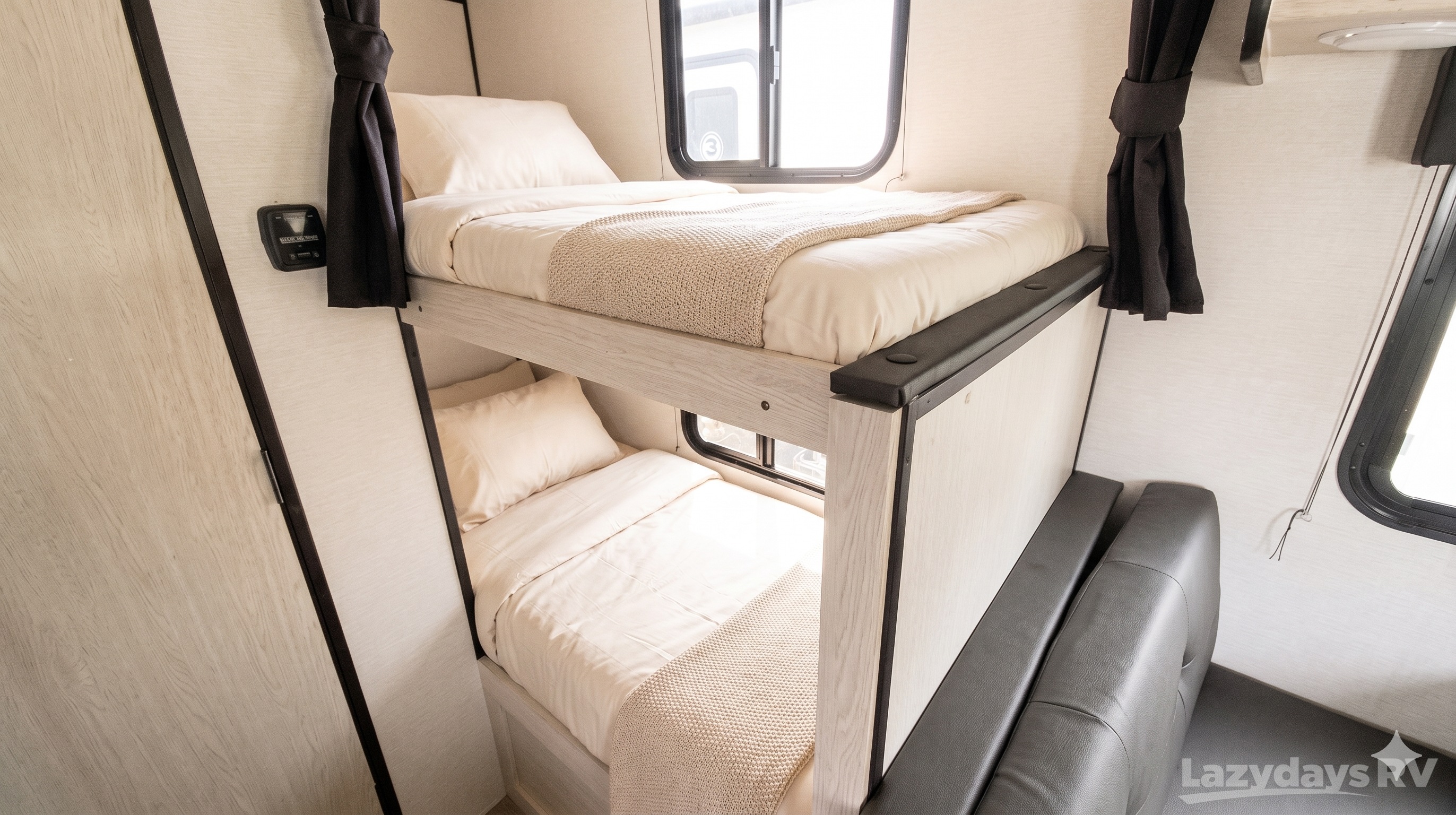 Cozy RV rental interior with two bunk beds, complete with light bedding and pillows, offering comfortable sleeping quarters.. Coachmen Apex Nano 2023
