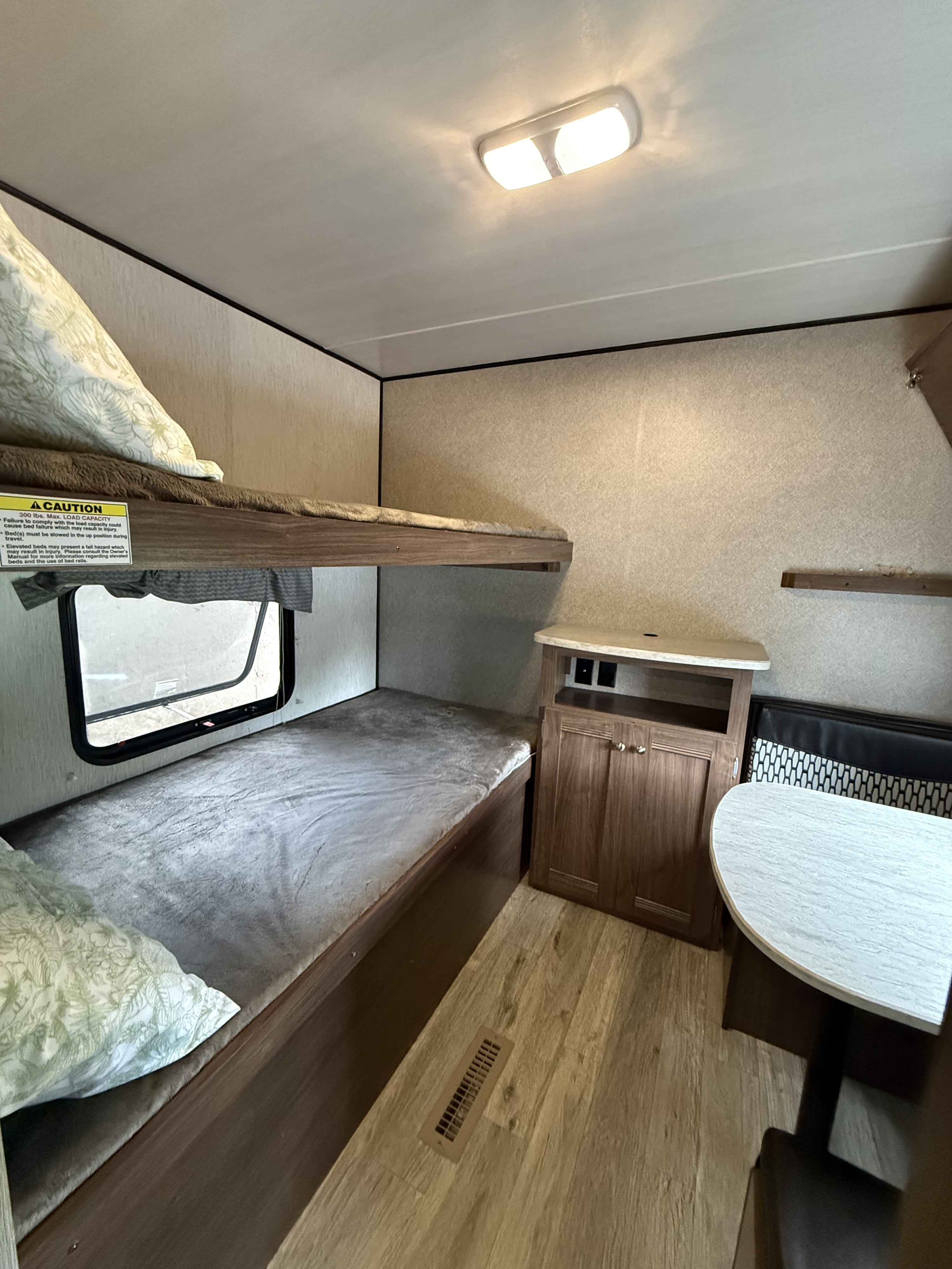 RV rental interior features bunk beds, a dinette, cabinet, and a visible load capacity caution sticker for the upper bunk.. Heartland RVs Prowler Lynx 2018