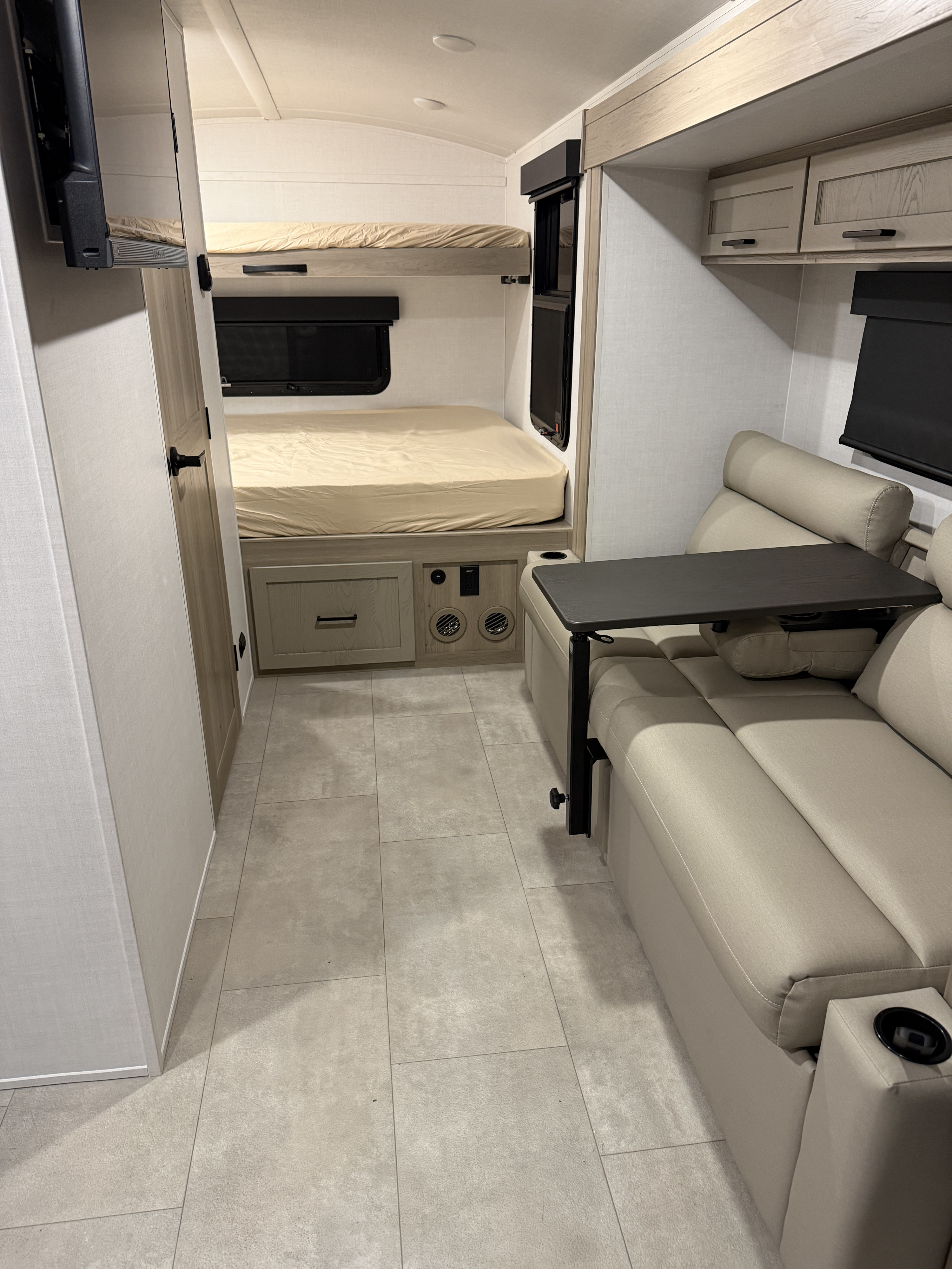 Modern rv rental interior featuring bunk beds, cozy seating with a movable table, and tiled flooring.. Forest River Rockwood Geo Pro 2026