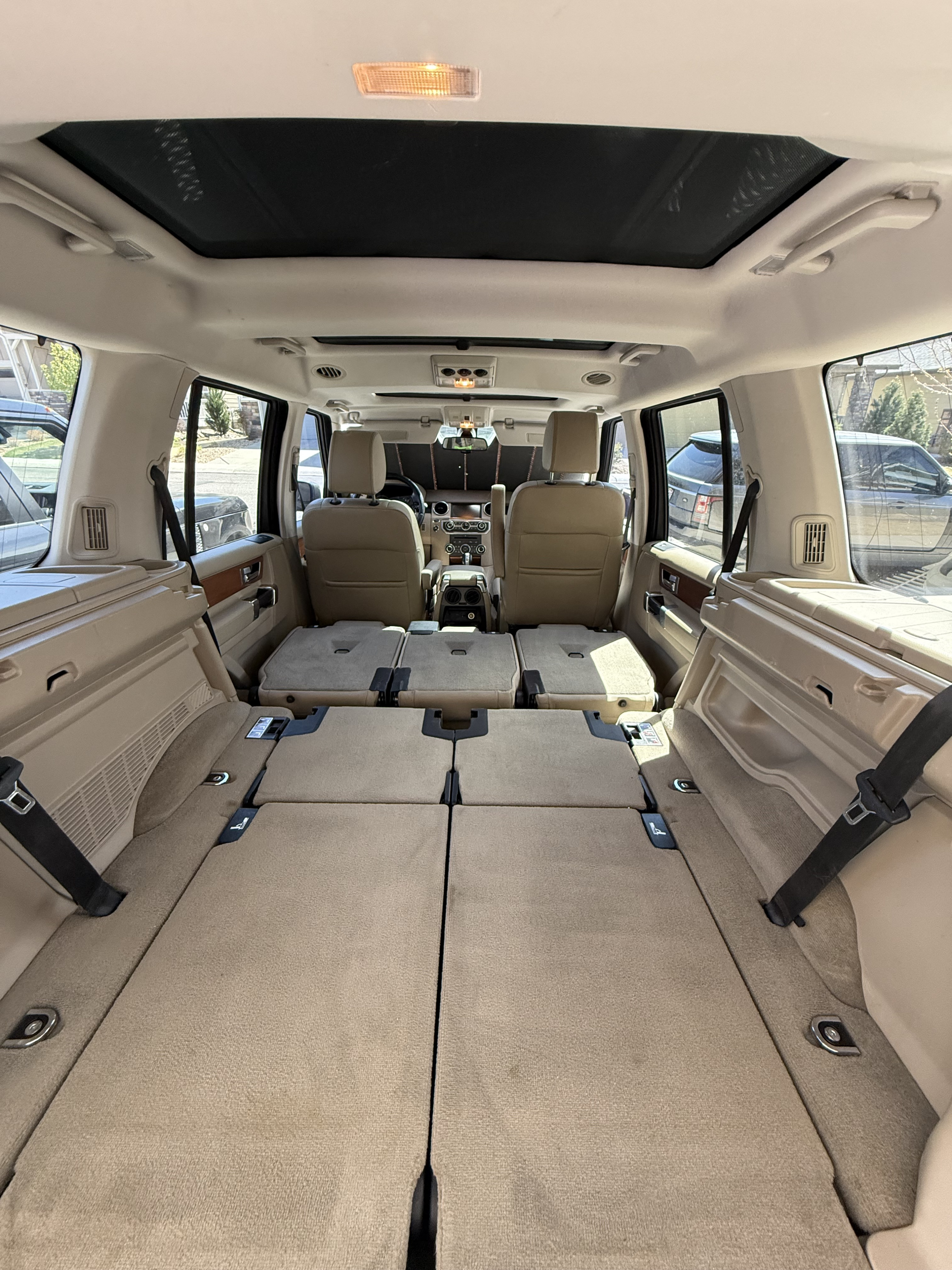 Spacious SUV interior with folded rear seats creating ample cargo, great for an RV rental alternative or travel.. Land Rover LR4 2010