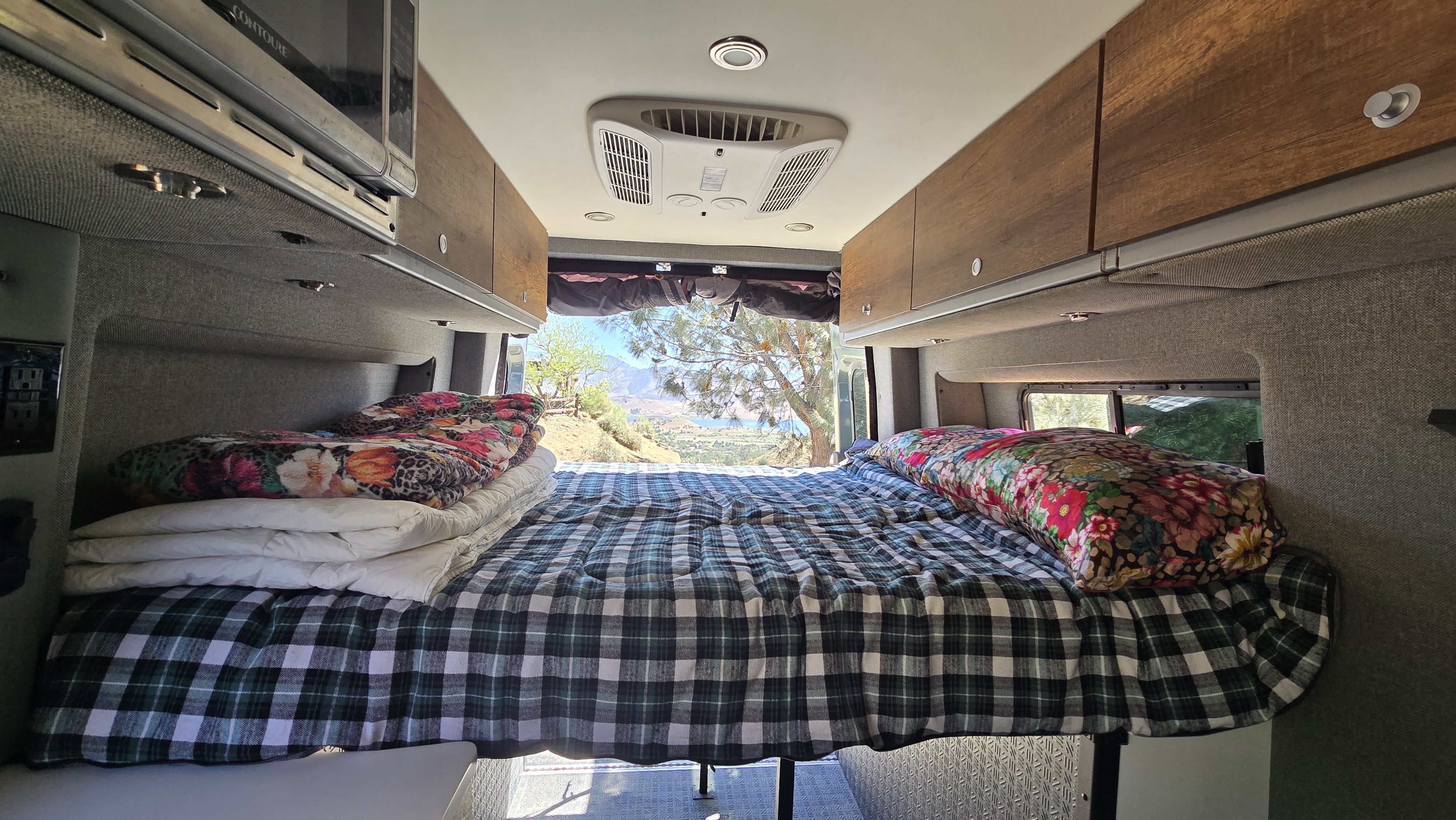 Enjoy this comfy RV rental bed & scenic mountain-lake view! Features include microwave, AC, and cozy blankets for your trip.. Storyteller Overland Storyteller Overland Class B 2022