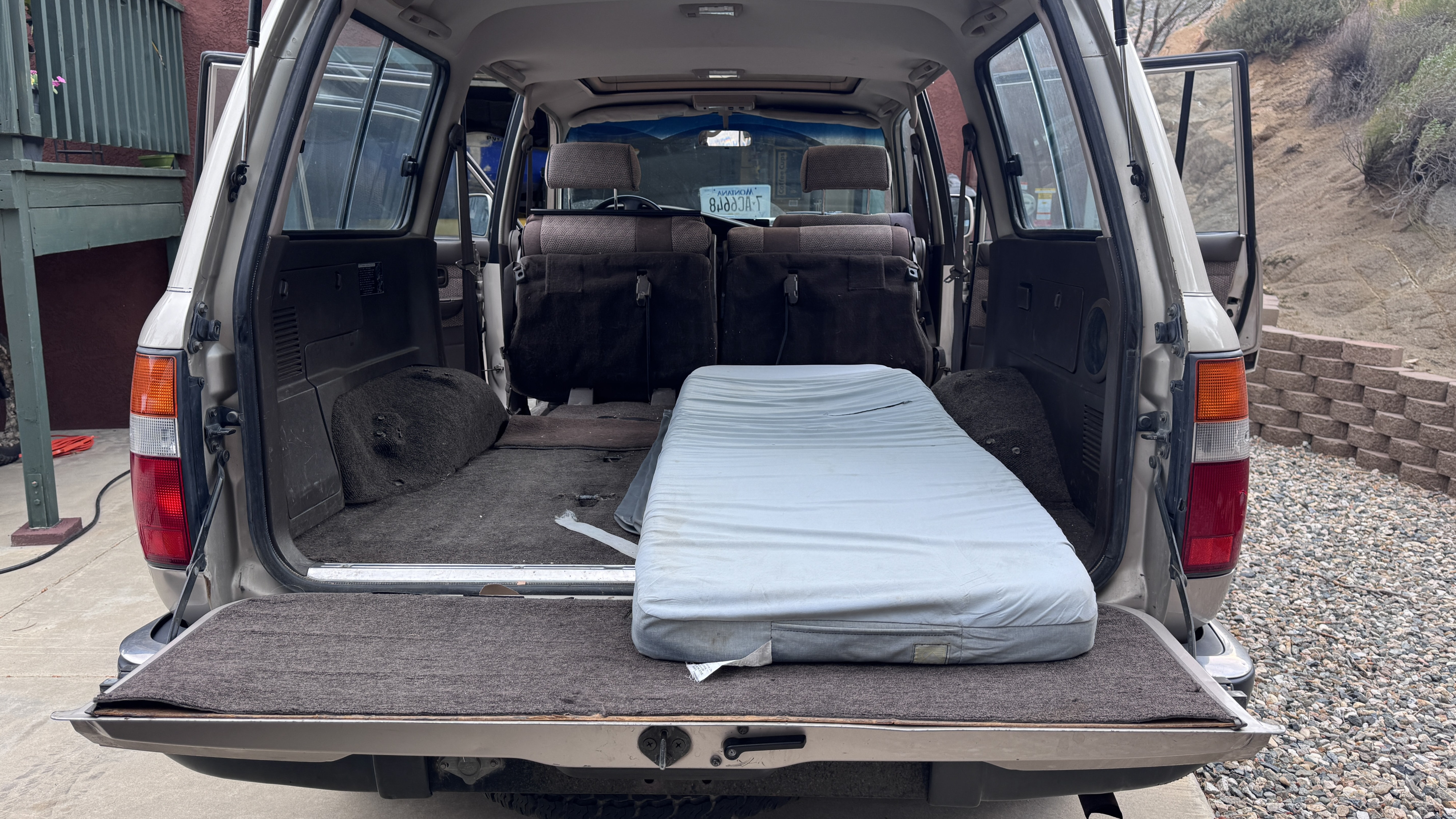 Open SUV tailgate with a mattress in the cargo area, ready for camping trips, a smart RV rental alternative.. Toyota FJ 80 Toyota Landcruiser 1991