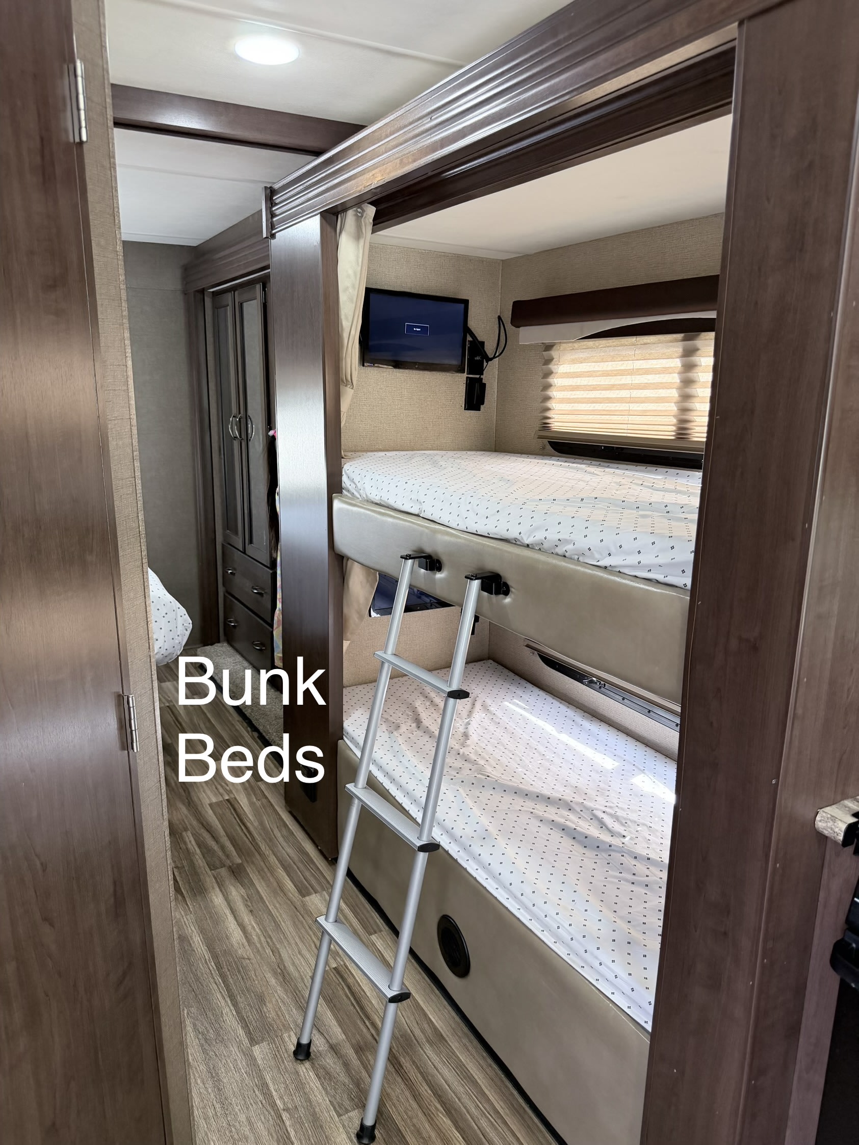 Inside this RV rental, comfortable bunk beds are ready, complete with a ladder and personal TV for travelers.. Thor A.C.E. 2018