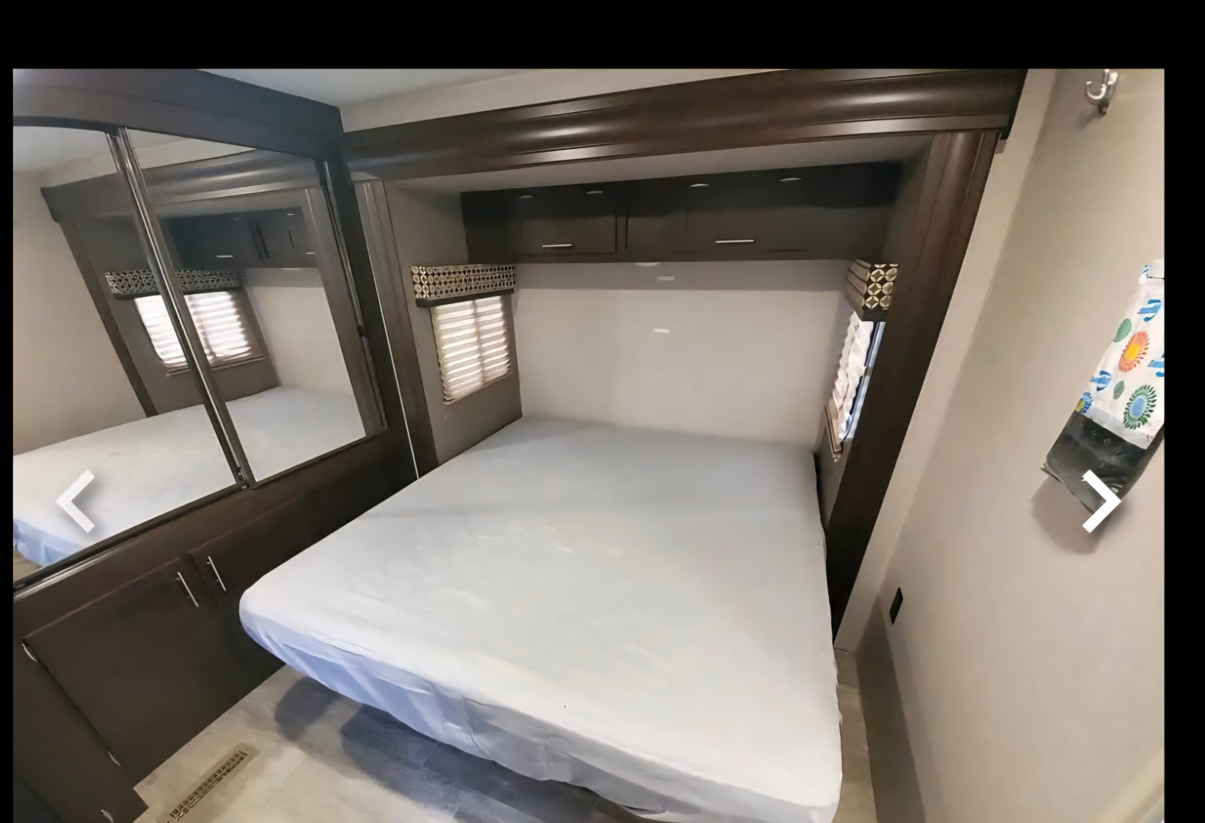 This RV rental bedroom features a comfy bed, mirrored closet, overhead storage, and a window with blinds.. KZ 362BH 2018