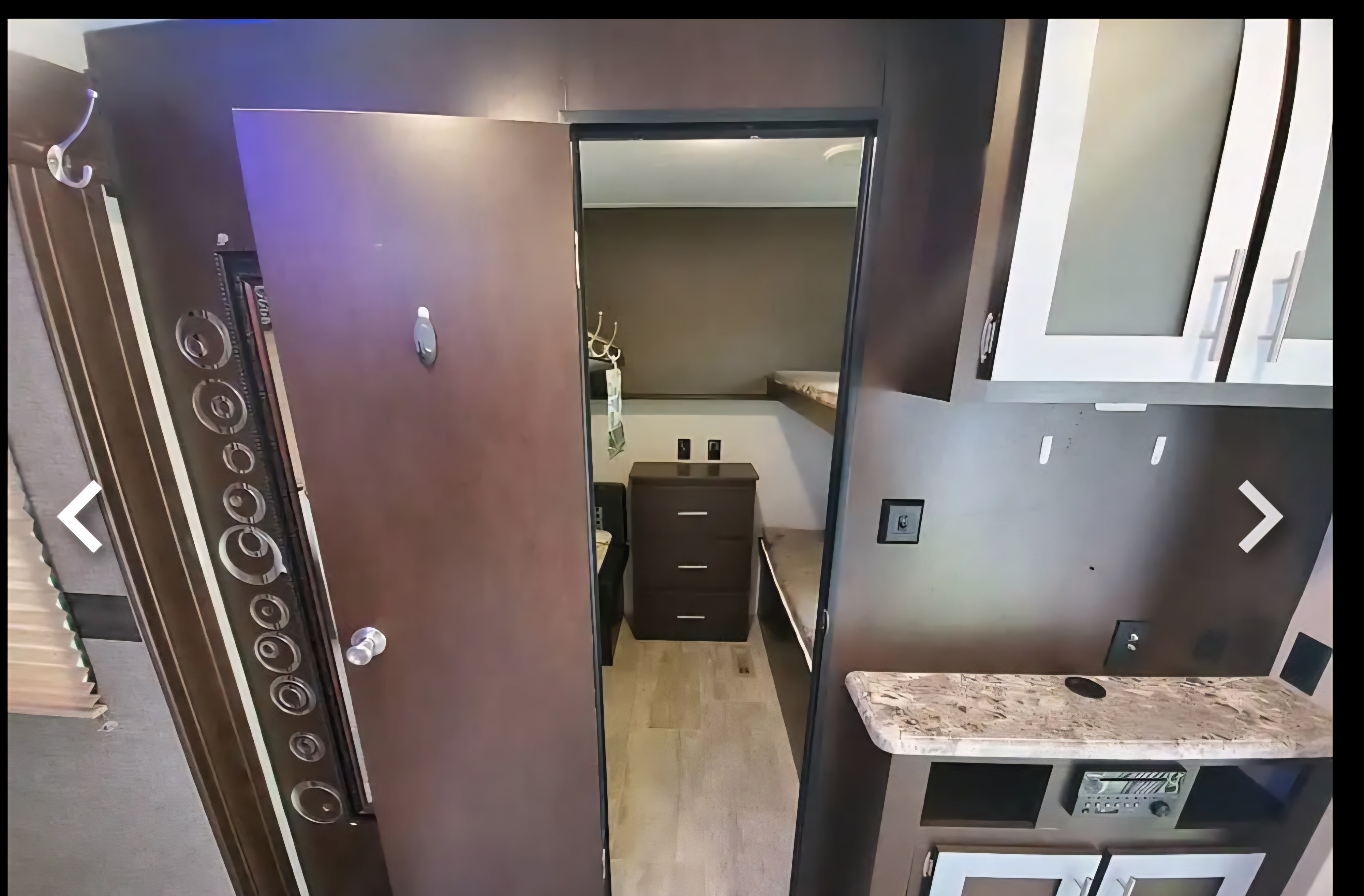 RV rental interior: Open door reveals a bunk room with storage. Main area has kitchen counter, cabinets, and a media console.. KZ 362BH 2018