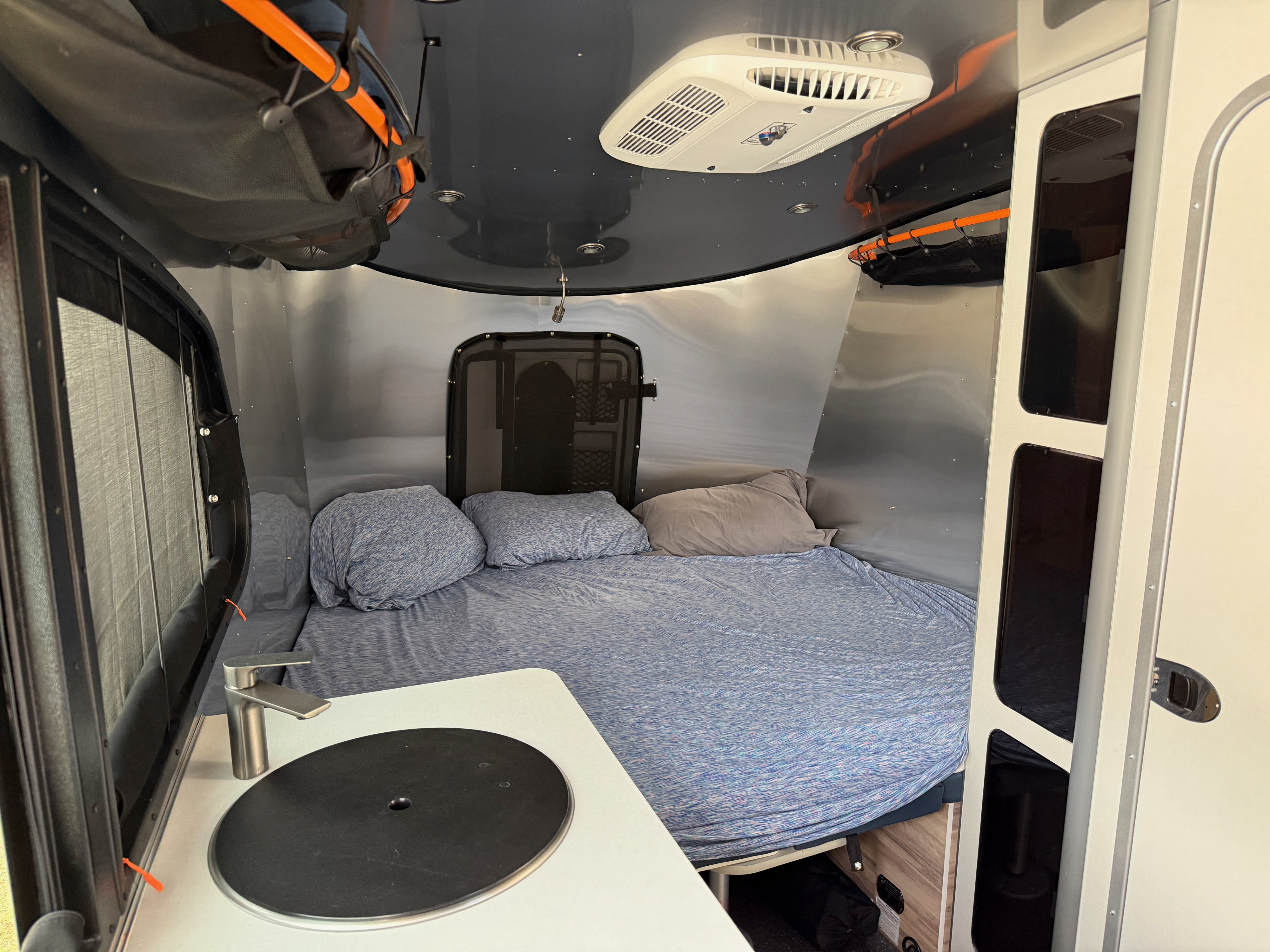 Cozy rv rental interior: bed, kitchenette, and AC for your adventures.. Airstream BaseCamp 20 2023