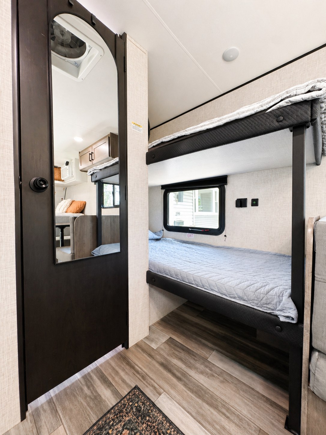 Cozy RV rental interior featuring modern bunk beds, a reflective door, and a compact living space, perfect for family adventures.. Jayco Jay Flight SLX 2025
