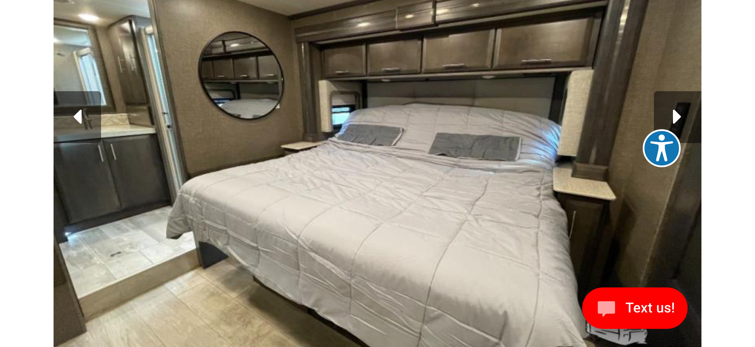 RV rental bedroom: cozy bed, overhead storage, and vanity access.. Thor Venitian 2021