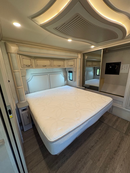 Spacious RV rental bedroom featuring a plush bed, stylish storage, and ambient lighting for comfortable travel.. Kountry Star Kountry Star Motorhome 2022