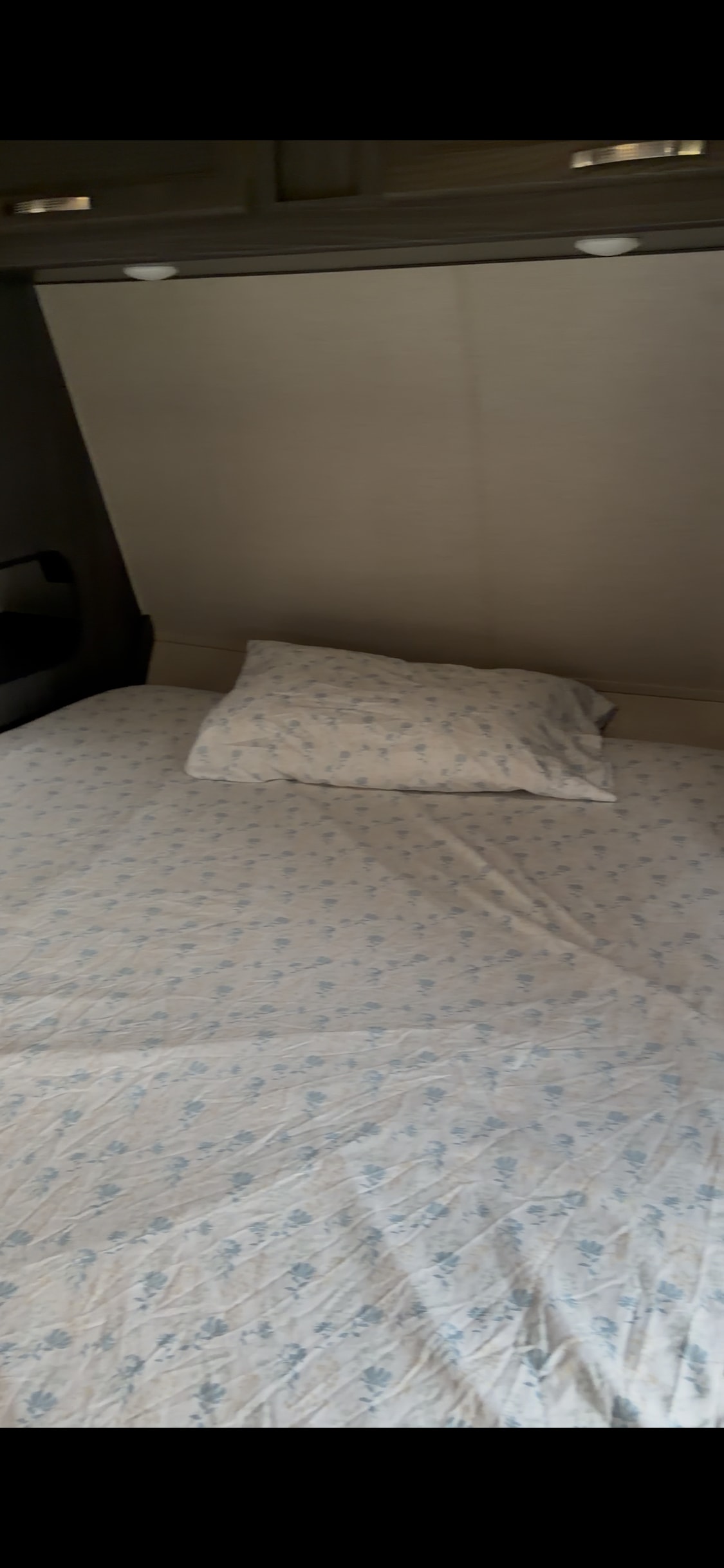 Cozy rv rental bed with white and blue floral sheets and pillow. Ready for a peaceful night's rest in a compact space.. Genesis Supreme Rv Genesis Supreme 2019